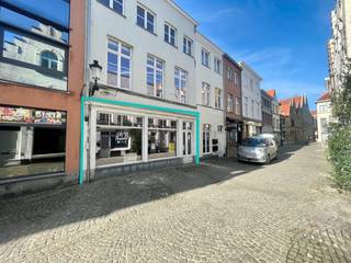 RUIM HANDELSGELIJKVLOERS op een unieke locatie in hartje Brugge. Op een gegeerde ligging in het historische centrum van Brugge, vlakbij het Koningin Astridpark, de Vismarkt, de Rozenhoedkaai, de Burg en de Markt, bevindt zich deze ruime handelsruimte met maar liefst 258 m² bruikbare vloeroppervlakte. De royale gevelbreedte (+/- 9,50m)  met mooie etalage zorgt voor een uitstekende visibiliteit en een sterke commerciële uitstraling. De handelsruimte wordt casco verkocht, waardoor je alle vrijheid krijgt om het pand volledig naar eigen smaak en volgens de noden van jouw concept in te richten. Van een stijlvolle horecazaak of een inspirerende kunstgalerij tot een elegante winkelruimte of een professionele kantooromgeving: de mogelijkheden zijn bijzonder veelzijdig.
Een extra troef is de achteruitgang naar het Pandreitje, die zorgt voor een bijkomende ontsluiting. EPC-label B. Wche,  bouwkundig erfgoed, Vg, Gmo, Gvkr, Gvv.
Een karaktervolle commerciële opportuniteit op een toplocatie, waar ruimte, zichtbaarheid en de charme van historisch Brugge samenkomen.
