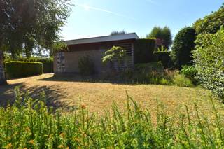 Op zoek naar een ruime, vrijstaande woning met bijzondere architectuur, veel parkeermogelijkheden én een uitzonderlijke werk- of hobbyruimte? <br />De woning ligt verscholen tussen tal van volwassen bomen, waardoor u geniet van een aangename buurt. Tegelijkertijd is er sprake van een uitstekende verbinding,<br /><br />Indeling als volgt:<br />Via de inkomhal, voorzien van een apart toilet, komen we in de leefkeuken en de ruime woonkamer. De living geniet dankzij de grote raampartijen van een prachtig en rechtstreeks zicht op de tuin, waardoor binnen en buiten mooi met elkaar verbonden worden.<br /><br />De woning beschikt verder over 3 slaapkamers en een badkamer met ligbad, lavabo en een tweede toilet.<br />Alles bevindt zich op het gelijkvloers, wat deze woning bijzonder praktisch maakt voor wie comfortabel en zonder trappen wil wonen.<br /><br />Aansluitend is er een garage met aanpalende bergruimte, ideaal voor fietsen, gereedschap en allerhande praktische zaken. De woning beschikt bovendien over een lange oprit, waardoor er bijzonder veel parkeermogelijkheden zijn op eigen terrein.<br /><br />Surplus een mooi stukje tuin, Zuidgericht. Ideaal om op zonnige dagen optimaal van de groene omgeving te genieten.<br /><br />Een absolute troef is de magazijnruimte van 205 m². Deze polyvalente ruimte opent de deur naar tal van mogelijkheden.<br /><br />Ook de kelder van 30m² zorgt voor extra bergruimte. Deze is bovendien rechtstreeks toegankelijk via het terras, wat het praktisch gebruik ervan alleen maar ten goede komt.<br /><br />De woning vraagt hier en daar om enkele opfrissingswerken, maar beschikt over een uitstekende basis en vooral over bijzonder veel potentieel.<br /><br />Onze ref. DEV5160<br />Stedenbouwkundige info in aanvraag.