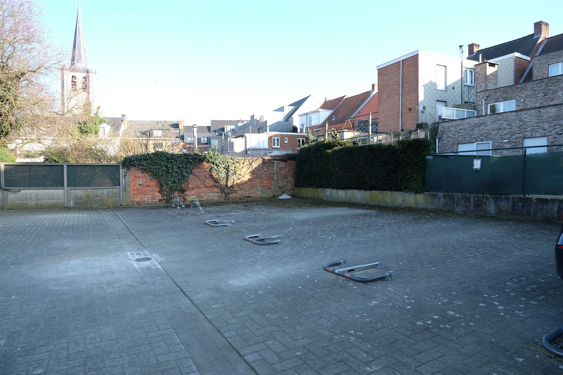 Buitenstaanplaats te huur achter gebouw. Onmiddellijk beschikbaar. Er is een beugel voorzien op de staanplaats.