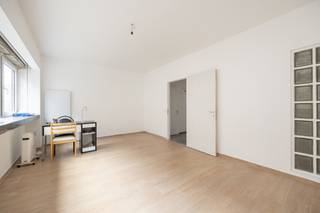 <p>In de sfeervolle Sint-Antoniusstraat, pal in het centrum van Turnhout, bevindt zich dit veelzijdige handelspand met duplexappartement en een bewoonbare oppervlakte van maar liefst 306 m². De locatie is een uitgesproken troef: een charmante straat met historisch karakter, op wandelafstand van winkels, horeca en openbaar vervoer, en tegelijk opvallend rustig gelegen.</p>
<p>Het gelijkvloers bestaat uit een ruime, open handelsruimte die dankzij meerdere lichtkoepels baadt in natuurlijk daglicht. Achteraan zijn een praktische berging en een afzonderlijk toilet voorzien. Deze verdieping leent zich uitstekend voor diverse commerciële invullingen.</p>
<p>Op de eerste verdieping bevindt zich een aangename, lichtrijke leefruimte met aansluitend een ruime keuken, uitgerust met vaatwasser, oven en koelkast. Daarnaast zijn er een handige berging en een apart gastentoilet.</p>
<p>De tweede verdieping omvat twee volwaardige slaapkamers, waarvan één met dressingruimte. De badkamer is uitgerust met een douche, lavabo en toilet. Aan de achterzijde bevindt zich een compact balkon dat een gezellige buitenruimte creëert midden in de stad.</p>
<p>Verder beschikt het pand over een ruime kelder, ideaal als extra opslag- of bergruimte.</p>
<p>Dit pand valt onder de renovatieverplichting van de Vlaamse overheid voor residentiële gebouwen (tenzij bij sloop binnen de 5 jaar na aankoop). Meer informatie is beschikbaar via het Vlaams Energie- en Klimaatagentschap.</p>
<p><strong>Troeven op een rij:</strong></p>
<ul>
<li>Lichtrijke handelsruimte met veel potentieel</li>
<li>Mogelijkheid tot een aparte inkom voor het woongedeelte</li>
<li>Interessant investeringspand met aantrekkelijk verhuurpotentieel</li>
</ul>