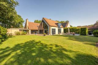 <p>Gelegen in een residentiële en groene woonomgeving bevindt deze villa zich op een royaal perceel van ca. 2.715 m², in een doodlopende straat. De fraai aangelegde tuin met vijverpartij geeft het geheel een aangenaam parkgevoel. Rust, ruimte en privacy zijn slechts enkele troeven van deze degelijke woning.<span></span></p>
<p>Bovendien is er weinig doorgaand verkeer, wat zorgt voor een veilige omgeving voor kinderen, wandelaars en fietsers. Het Zoerselbos, met ca. 400 hectare natuurgebied, bevindt zich op slechts 3 km afstand.</p>
<br /><span><strong>Indeling<br /><br /></strong></span>Inkomhal met gastentoilet voorzien van handenwasser, vestiaireruimte en toegang tot een polyvalente kamer van ca. 10 à 12 m², momenteel ingericht als hobbykamer. Verder bereikt u de leefruimte, die gekenmerkt wordt door royale volumes en veel natuurlijke lichtinval. Deze omvat momenteel een bureau met open haard en zicht op de tuin, een ruime zithoek met plafondhoogte tot in de nok en voorzien van een houtkachel, een afzonderlijk tv-salon, een eetkamer en een volledig ingerichte keuken (2000).
<p>Vanuit de keuken is er toegang tot de inpandige garage met aparte wasplaats. Via de garage bereikt u tevens de droge, geklimatiseerde wijnkelder.</p>
<span><strong>Verdieping<br /><br /></strong></span>De verdieping beschikt over twee met elkaar verbonden overlopen. De eerste, bereikbaar vanuit de inkomhal, geeft toegang tot drie slaapkamers. De tweede overloop, die eveneens rechtstreeks vanuit de leefruimte bereikbaar is, leidt naar de ruime hoofdslaapkamer met een grote ingemaakte kastenwand.
<p>De twee overlopen vloeien in elkaar over, maar kunnen desgewenst van elkaar worden gescheiden door middel van een deur.<span></span></p>
<p>Daarnaast omvat deze verdieping een ruime berging met Velux-dakraam, een badkamer met dubbele lavabo, ligbad en douche, en een afzonderlijk nachttoilet.<br /><br />Het creëren van een tweede badkamer is relatief eenvoudig realiseerbaar.</p>
<br /><span><strong>Tuin<br /></strong></span><br />Volledig omheinde tuin met een afsluiting van ca. 1,80 m hoog. De tuin beschikt over een grote vijverpartij, twee terrassen en een boomgaard.<br /><br /><span><strong>Bijzonderheden</strong></span>
<ul>
<li>Bevloering in natuursteen en parket</li>
<li>Verwarming deels elektrisch (radiatoren en accumulatoren) en deels op aardgas (vloerverwarming)</li>
<li>Houten en aluminium ramen met dubbele beglazing</li>
<li>Droge, geklimatiseerde wijnkelder</li>
<li>Voorzieningen voor aansluiting op de riolering zijn reeds aanwezig</li>
<li>EPC: label D – 326 kWh/m² jaar - <span><strong>EPC label C </strong></span>na plaatsen zonnepanelen (simulatie)</li>
<li>EPC-certificaat: UC 3890393</li>
<li>Elektriciteit wordt conform opgeleverd</li>
</ul>
<p><span><strong><br />Stedenbouwkundige inlichtingen</strong></span><span></span></p>
<p>Vg – Wg – Gvv – Gvkr – Gmo – Gworg</p>