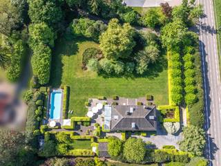 <p><strong>Met gepaste trots stellen wij u dit unieke pareltje voor, op een boogscheut van het centrum van Lier.</strong><br />Dit domein van 3.877 m² ligt uiterst landelijk en rustig, maar is tegelijk vlot bereikbaar via de E19. Zowel het stadscentrum als het Netelandschap bevinden zich op wandel- en fietsafstand.</p>
<p>De eigenaars kozen hier voor een prachtig, authentiek gebouw met hoogwaardige, natuurlijke bouwmaterialen zoals extra dikke eikenhouten vloeren, massieve houten maatwerkkasten en -deuren, en natuursteen. Met de schitterende orangerie, de fantastische tuin en het extra lange zwembad heerst hier een echt vakantiegevoel.</p>
<p>Een deel van het perceel is vergund verkaveld als bouwgrond, wat heel wat mogelijkheden biedt: een extra praktijkruimte voor een vrij beroep, een tweede woning voor een familielid of een toekomstige verkoop.</p>
<p><strong>Indeling</strong></p>
<p><strong>Gelijkvloers</strong><br />Bij het binnenkomen valt de authentieke sfeer meteen op. Vanuit de statige inkomhal met gastentoilet en vestiaire komt u rechtstreeks in de ruime leefruimte met open haard aan de ene zijde en een fantastische leefkeuken aan de andere. De woonkamer bestaat uit een stijlvolle eetkamer, een ruime living en een bibliotheek/tv-hoek in de opkamer. Dankzij de grote raampartijen en erkers baadt de ruimte in natuurlijk daglicht en geniet u van een panoramisch uitzicht op de tuin. De leefkeuken, met kookeiland en ontbijthoek, is rijkelijk uitgerust met alle nodige toestellen en massieve houten kasten. Ze biedt toegang tot een sfeervolle orangerie met directe verbinding naar het zonnige terras en de tuin.<br />Naast de keuken bevindt zich een praktische, authentieke sas/mudroom met zij-ingang, toilet, ruimte voor een douche en toegang tot de ruime wasplaats.</p>
<p><strong>Kelder</strong><br />Via de keuken bereikt u de kelder, bestaande uit 3 aparte delen: een bergkelder, een wijnkelder en een technische ruimte.</p>
<p><strong>Verdieping</strong><br />Een elegante blauw hardsteen trap leidt naar de verdieping, waar zich de master bedroom, 3 slaapkamers en 2 badkamers bevinden. De ruime master bedroom beschikt over een volledige kastenwand en een luxe marmeren badkamer, inclusief terrasje met uniek zicht op de tuin. Aan de andere zijde van de verdieping bevinden zich de 2de, 3rde en 4rde slaapkamer, waarvan twee voorzien van ingemaakte kasten. De 2de badkamer beschikt over een dubbele wastafel, bad, douche en toilet. Grote ramen zorgen ook hier voor licht en zicht op de tuin.</p>
<p><strong>Zolder</strong><br />Via een vaste, mooie eiken trap bereikt u de volledig geïsoleerde zolder, waar ruimte is voor minstens drie extra slaapkamers en een badkamer (leidingen reeds voorzien).<br /><br /><strong>Buiten<br /></strong>De prachtig aangelegde volwassen parktuin beschikt over meerdere terrassen, zodat u op elk moment van de dag kunt genieten van de zon. Het extra lang verwarmd zwembad met ruime terrassen en een schaduwtent maakt het plaatje compleet. Achteraan ter hoogte van het zwembad bevindt zich een serre, dewelke dienst doet als technische ruimte en kleedruimte met daarnaast een buitendouche. Praktisch is ook het ruime bijgebouw, ideaal voor fietsen en extra opbergmogelijkheden.<br /><br /><strong>**De woning is momenteel gelegen op 2 bouwgronden. <span>Er bestaat bijgevolg de mogelijkheid om de villa aan te kopen zonder de naastliggende bouwgrond, </span>die vandaag volledig als tuin wordt gebruikt. </strong></p>
<p><strong><br />Bijzonderheden</strong></p>
<ul>
<li>Gebouwd met oog voor kwaliteit en vakmanschap</li>
<li>Extra hoge plafonds met sierlijsten</li>
<li>Gunstig EPC</li>
<li>Ruime kelder</li>
<li>Prachtige parktuin</li>
<li>12m verwarmd zwembad met warmtepomp</li>
<li>Geïsoleerde zolder met talrijke mogelijkheden</li>
<li>360° groen!</li>
</ul>
Voor meer informatie of een bezoek van deze prachtige woning kan u contact nemen met Sigalit via Sigalit@reds.be of op 0475668474