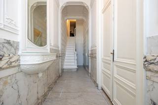 Dit gelijkvloers appartement bevindt zich in een herenhuis, opgedeeld in 4 units. Privé entree met marmer, twee prachtige ruimtes met hoge plafonds, originele plafonds en schouw. Vooraan mogelijks ontvangstruimte of bureau. Middenplaats momenteel ruim salon. Achteraan volwaardig geïnstalleerde keuken met eetplaats, aansluitend het terras. Verder op het gelijkvloers ruime master bedroom met badkamer. Op de eerste verdieping bevinden zich nog een grote en een kleine slaapkamer met badkamer. Wasplaats.