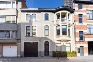 In de<strong> gegeerde Arbeidstraat</strong>, op een steenworp van het historische stadscentrum, schuilt achter deze statige gevel een zeldzaam baken van rust, ruimte en hedendaagse esthetiek. Deze herenwoning <strong>onderging in 2011 een diepgaande en smaakvolle totaalrenovatie, </strong>waarbij authentieke grandeur harmonieus samensmelt met een hoogwaardige moderne afwerking. Met een royale bewoonbare oppervlakte van ca. <strong>310 m²</strong> biedt deze eigendom een ongeëvenaard wooncomfort in het centrum van de stad. <strong>Op het gelijkvloers</strong> verwelkomt de stijlvolle inkomhal je naar een riante leefruimte met een prachtige authentieke schouw, <strong>die tevens perfect dienst kan doen als kantoor, praktijk of vrij beroep.</strong> Aansluitend vind je een keuken, een recent vernieuwde badkamer, een praktische inpandige garage en een eerste groot terras met 100% privacy. <strong>De 1e verdieping</strong> herbergt <strong>3 bijzonder ruime slaapkamers</strong> en een riante badkamer met ligbad, inloopdouche, dubbele lavabo en toilet. Onder het dak wacht <strong>een volwaardig ingerichte loftverdieping</strong> met een eigentijdse look, compleet met eigen keuken, gezellige zithoek met gasvuur en een directe toegang tot een tweede, ruim zonovergoten dakterras met open zicht. Een <strong>droge kelder</strong> zorgt voor extra bergruimte. Deze unieke woning combineert authentieke charme met hedendaags comfort, is asbestveilig, heeft<strong> een conforme elektriciteitskeuring </strong>én beschikt over een uitstekend <strong>EPC-label B.</strong> Een instapklare buitenkans op wandelafstand van alles wat de stad te bieden heeft! Achtergevel recent compleet vernieuwd en geïsoleerd. Asbestveilig. CV Aardgas. 