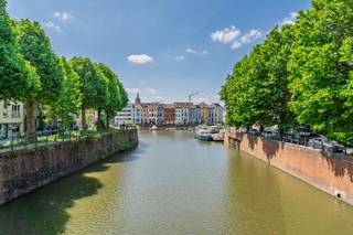 Bent u op zoek naar een woning in Gent die u <strong>volledig naar eigen smaak kunt inrichten</strong>? Dan is dit pand precies wat u zoekt. Met een <strong>bewoonbare oppervlakte van circa 195 m²</strong> biedt deze woning een unieke kans om uw droomhuis te realiseren op een topligging.<br /><br />LIGGING<br /><br />Deze ruime, op te frissen woning is ideaal gelegen in een sfeervolle, met <strong>platanen omzoomde éénrichtingsstraat langs de Leie</strong>. Hier woon je in het kloppend hart van Gent, op wandelafstand van <strong>historische trekpleisters</strong> zoals de Vrijdagmarkt, Sint-Jacobs, de Vlasmarkt, het Belfort en de Korenmarkt. Dankzij de centrale ligging geniet je van een uitstekende bereikbaarheid met winkels, scholen, supermarkten en openbaar vervoer letterlijk om de hoek. Het station <strong>Gent-Dampoort</strong> bevindt zich op 400 meter van de woning.<br /><br />Bovendien bevind je je vlak bij het <strong>Baudelopark</strong> en <strong>het idyllische Portus Ganda</strong> — ideaal voor wie graag geniet van groen en water in de stad. Mobiscore van 9,4/10.<br /><br />INDELING<br /><br />Via de <strong>centrale inkomhal</strong> betreedt u de woning, die meteen toegang geeft tot de lichtrijke leefruimte met eetplaats en uitgeruste keuken. De raampartijen zorgen hier voor een warme, gezellige sfeer. Op het gelijkvloers bevinden zich bovendien een praktische <strong>bergruimte</strong> en badkamer met toilet.<br /><br />Op de eerste verdieping bevinden zich <strong>twee volwaardige slaapkamers</strong>, waarvan één met een prachtig <strong>uitzicht op de Leie</strong> — een zeldzame troef in het centrum van Gent. De tweede verdieping biedt nog eens <strong>twee extra slaapkamers</strong>, ideaal voor een groter gezin, een bureau of hobbyruimte.<br /><br />Tot slot beschikt de woning over een <strong>kelder</strong> en een ruime <strong>zolder</strong>.<br /><br />TROEVEN<br /><br />- <strong>Unieke ligging aan de Leie, in het historische centrum van Gent</strong><br />- Ruime woning met enorm veel potentieel<br />- Ideaal als woonst voor een gezin of als investering met goede verhuurmogelijkheden<br /><br />Laat deze kans niet liggen! Neem vandaag nog contact op met Bram via +32 471 76 90 50