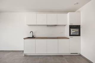 <p><strong>Compact en energiezuinig nieuwbouwappartement</strong></p>
<p><strong> met terras in centrum Kapellen</strong></p>
<p>Gelegen in het hart van Kapellen, op wandelafstand van winkels, openbaar vervoer en andere faciliteiten, bevindt zich dit nieuwbouwappartement van 55 m² op de eerste verdieping. Dit energiezuinig éénslaapkamerappartement is perfect voor alleenstaanden of koppels die op zoek zijn naar een comfortabele woonst met moderne afwerking.</p>
<p><strong>Indeling van het appartement</strong></p>
<ul>
<li>
<p><strong>Inkomhal</strong></p>
</li>
<li>
<p><strong>Leefruimte met open keuken</strong>, met toegang tot het terras aan de voorzijde</p>
</li>
<li>
<p><strong>Open keuken</strong> voorzien van inductiekookplaat, dampkap, spoelbak, combi-oven en vaatwasser</p>
</li>
<li>
<p><strong>Terras aan de voorzijde</strong>, ideaal om even buiten te vertoeven</p>
</li>
<li>
<p><strong>Slaapkamer</strong> met directe toegang tot de badkamer</p>
</li>
<li>
<p><strong>Badkamer</strong> met ruime inloopdouche en lavabo</p>
</li>
<li>
<p><strong>Technische ruimte/wasplaats</strong></p>
</li>
<li>
<p><strong>Apart toilet</strong></p>
</li>
</ul>
<p><strong>Bijzonderheden</strong></p>
<ul>
<li>
<p>Overal <strong>keramische grijze tegelvloer</strong></p>
</li>
<li>
<p><strong>Aluminium schrijnwerk</strong> met zonwerende beglazing</p>
</li>
<li>
<p><strong>Zonnepanelen</strong></p>
</li>
<li>
<p><strong>Warmtepomp lucht-lucht</strong> en <strong>vloerverwarming</strong></p>
</li>
<li>
<p><strong>Te behalen E-peil: 24</strong></p>
</li>
<li>
<p><strong>Regenwaterrecuperatie</strong> voor de toiletten</p>
</li>
<li>
<p><strong>Maandelijkse provisie van € 10 voor waterverbruik</strong></p>
</li>
<li>
<p><strong>Ingaande plaatsbeschrijving</strong> via extern expertisebureau: € 250 inclusief 21% BTW</p>
</li>
<li>
<p><strong>Eindplaatsbeschrijving</strong> bij vertrek: € 181,50</p>
</li>
<li>
<p><strong>Waarborg van 3 maanden</strong>, geregeld via <strong>Korfine</strong></p>
</li>
</ul>
<p><br />Dit praktisch en energiezuinig nieuwbouwappartement is ideaal gelegen in het centrum van Kapellen en biedt alles wat je nodig hebt op een compacte oppervlakte. Perfect instapklaar, met moderne voorzieningen en een mooi terras. Interesse? Neem vrijblijvend contact op via 03 535 12 75 voor meer informatie of een bezoek.</p>