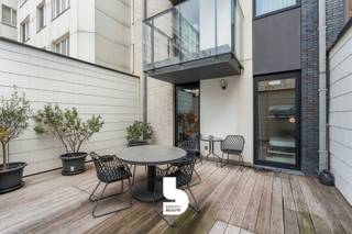 Op amper 30 meter van de zeedijk bevindt zich dit moderne en lichtrijke gelijkvloerse appartement met zijdelings zeezicht, twee slaapkamers en een exclusief zonneterras van maar liefst 28 m². De recente residentie onderscheidt zich door haar eigentijdse architectuur en biedt dankzij slechts één appartement per verdieping een extra gevoel van rust en privacy.<br /><br />Het appartement is stijlvol en luxueus ingericht, met bijzondere aandacht voor een optimaal ruimtegebruik. De praktische inbouwkasten, waaronder een opklapbaar bed, zorgen voor extra comfort en opbergruimte. Met twee slaapkamers biedt het appartement plaats aan vier personen, waardoor het ideaal is als tweede verblijf aan zee of als comfortabele eigen woonst.<br /><br />Een absolute troef is het ruime, volledig afgesloten zonneterras van 28 m², rechtstreeks toegankelijk vanuit het appartement en ideaal om in alle privacy van de zon te genieten. Dankzij de ligging op het gelijkvloers is het appartement bovendien bijzonder vlot toegankelijk.<br /><br />De residentie beschikt over een ruime lift die conform is aan de geldende normen. Daarnaast zijn er een gemeenschappelijke fietsenberging en extra bergruimte, zowel in het appartement zelf als in de kelder.<br /><br />De ligging is bijzonder gunstig: op wandelafstand vind je het openbaar vervoer, restaurants, winkels, het warenhuis, het nieuwe stedelijke zwembad en diverse sportfaciliteiten, waaronder golf, voetbal en basketbal.<br /><br />Tot slot beschikt het appartement over een blanco elektrische keuring.