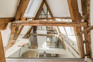 <p>Deze prachtige ruime, monumentale designloft bevindt zicht op de eerste verdieping en is bereikbaar via de trap. De loft heeft een bewoonbare oppervlakte van 170 m² en is gelegen in het historische stadscentrum van Mechelen met de Kruidtuin als directe achtertuin. Het pand beschikt over een hoogwaardige renovatiegeschiedenis waarbij het zowel structureel als esthetisch volledig heropgebouwd is naar een ontwerp van ARAS architecten. Hierbij werd er gewerkt met kwalitatieve en hoogwaardige materialen alsook werd er rekening gehouden met een optimale indeling van de ruimtes. Een enorm ruimtegevoel werd gecreëerd door grote raampartijen, een goede vormgeving en de juiste oriëntatie waarbij het behoud van authentieke elementen centraal staat. De uitzonderlijk gevelbreedte (+/- 13m) voor een woning in de binnenstad zorgt voor veel daglicht in de ruimtes, zowel op het gelijkvloers als op de verdiepingen.</p>
<p>Bij het betreden van het pand krijg je een instant wauw-gevoel door de hoge plafonds, blootgelegde bakstenen wand, eikenhouten vloeren, stalen raamprofielen, gietvloeren en een open houten dakgebinte in combinatie met modern comfort en warme materialen. De royale leef- en eetruimte zijn volledig opengetrokken waarbij de designkeuken het centrale hart vormt van de ruimte. Deze beschikt over een centraal kookeiland met geïntegreerde zitmogelijkheid en is volledig uitgerust met kasten en toestellen.</p>
<p></p>
<p>Via de grote glaspartij met openslaande deuren heeft u toegang tot een groot, dakterras (87 m²) met houten terrasplanken waar u in alle privacy en rust kan genieten.</p>
<p>Op de tweede verdieping is er een ruime nachthal met een glazen borstwering op de vide waardoor u een connectie blijft ervaren met de andere verdiepingen. Deze verdieping omvat de masterbedroom met een ensuite badkamer voorzien van een vrijstaand ligbad, lavabomeubel en een moderne stalen glaswand. Daarnaast bevinden zich hier twee extra slaapkamers (waarvan één met een authentieke bakstenen accentmuur), elk voorzien van een individuele badkamer met inloop-regendouche. Tevens uitgerust met een apart toilet en een praktische wasruimte.</p>
<p>Op de derde verdieping is er een grote, multifunctionele mezzanine gesitueerd onder het indrukwekkende, open houten dakgebinte. Deze met dakramen uitgeruste ruimte kan flexibel worden benut als vierde slaapkamer, thuiskantoor, logeerkamer of speelruimte.</p>
<p>Het gebouw omvat slechts één ander appartement, wat zorgt voor een rustige en exclusieve woonomgeving.</p>
<p>Deze woning is ideaal voor mensen die van ruimte en modern comfort houden en de aanwezigheid van zeer veel natuurlijk daglicht in hun woning cruciaal vinden. Daarnaast zorgt de locatie voor een ultieme stadsbeleving zonder in te boeten aan luxe of privacy.</p>
<p>Laat deze unieke kans niet voorbij gaan!</p>