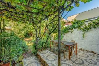 <p><span> </span></p><p><span>Op zoek naar een huis met karakter én een tuin waar je echt iets aan hebt? In deze rustige buurt in Borgerhout krijg je veel woonplezier, hoge plafonds, mooie plankenvloeren, authentieke details en een heerlijke west-gerichte tuin van ca 130 m². Met 3 volwaardige slaapkamers, een extra bureau/dressing, een grote droge kelder en het Te Boelaerpark vlakbij is dit een heerlijke gezinsplek.</span></p><p><span> </span></p><p><span>Authentieke charme & veel licht</span></p><p><span>Je komt binnen in een ruime inkomhal, en die zet meteen de toon. De originele terrazzovloer en sierlijsten geven het huis instant karakter. De originele trap met sierlijke rode leuning maakt het plaatje compleet. Vooraan ligt de leefruimte, een fijne, lichte plek met hoge plafonds, een grote raampartij aan de straatzijde en een warme plankenvloer. De sierboog deelt de ruimte subtiel op, zonder het open gevoel kwijt te spelen. Achteraan wacht een leefkeuken. De groene kasten, het houten werkblad en de vloer zorgen voor een gezellige, huiselijke sfeer. Je hebt hier een gasvuur, oven, dampkap, grote spoelbak, vaatwasser en heel wat werk- en kastruimte. Plaats genoeg ook voor een grote eettafel. Dankzij het raam, de lichtkoepel en vooral het grote schuifraam richting tuin komt hier massa’s licht binnen. </span></p><p><span>En dan die tuin! Met zo’n ca 134 m² en een westoriëntatie heb je hier een verrassend grote, groene buitenplek midden in de stad. Vlak bij de keuken ligt het betegelde terras, deels overgroeid door een druivelaar: een zalige plek voor lange etentjes buiten. Verderop wordt de tuin lekker groen, met gras, bomen en struiken die voor een fijne, natuurlijke sfeer zorgen.</span></p><p><span>Op het gelijkvloers vind je ook de badkamer, ingericht met een douche, hangtoilet, groot lavabomeubel en ingemaakte kasten. Een tof detail is het gekleurde glas dat opnieuw wat authenticiteit toevoegt.</span></p><p><span> </span></p><p><span>Slapen met zicht op het groen</span></p><p><span>Op de eerste verdieping liggen 3 slaapkamers en een extra kamer die vandaag perfect dienst kan doen als bureau, dressing of kinderkamer. De grootste slaapkamer aan de straatzijde, heeft een parketvloer en kijkt uit op het groen van de straatboom. Aan de tuinzijde liggen nog twee slaapkamers, allebei op plankenvloer en met zicht op de groene achtertuin. Vooraan is er nog een extra kamer van ca. 5 m²: ideaal als thuisbureau, dressing, babykamer of handige berging. Ook de overloop krijgt natuurlijk licht binnen via een lichtkoepel. </span></p><p><span>Onder het huis zit bovendien nog een kelder van ca. 30 m² met aansluiting voor een wasmachine en vooral héél veel opslagruimte.</span></p><p><span> </span></p><p><span>Groen wonen in Borgerhout</span></p><p><span>Je woont hier in de Spillemansstraat, een rustige buurt waar heel wat jonge gezinnen hun plek gevonden hebben. Het Te Boelaerpark ligt vlakbij voor een wandeling, een rondje joggen of wat groen met de kinderen. Een Delhaize vind je om de hoek en ook voor leuke horeca hoef je niet ver. Met busverbindingen in de buurt en een Velo-station aan het Te Boelaerpark geraak je bovendien vlot richting de rest van de stad.</span></p><p><span> </span></p>