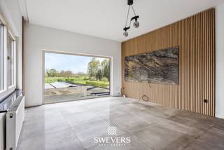 Voor meer info en foto’s, surf naar www.swevers.be – Dit ruime en instapklare appartement op de eerste verdieping in de Larenstraat 67 in Lummen werd oorspronkelijk gebouwd in 1976 en kreeg in 2022 een grondige renovatie. Met een bewoonbare oppervlakte van 123 m² en gelegen op een perceel van 14a 25ca geniet u hier van een hedendaagse afwerking, veel lichtinval en een praktische indeling. De centrale inkomhal leidt naar de lichtrijke leefruimte van 33,6 m², waar u vlot een gezellige zithoek en eethoek kan inrichten. Aansluitend bevindt zich de functionele keuken van 10 m², die mooi aansluit op het leefgedeelte. Het appartement beschikt over maar liefst 4 volwaardige slaapkamers van 11,5 m², 11 m², 11 m² en 23 m². De grootste kamer biedt extra mogelijkheden als master bedroom met dressing of bureau. In alle slaapkamers ligt parket, wat zorgt voor een warme uitstraling. De badkamer is uitgerust met een douche en er is een apart toilet aanwezig. Extra troeven zijn de privatieve garage van 20 m², de ruime gemeenschappelijke tuin van 876 m² met noordelijke oriëntatie en de aanwezigheid van 24 zonnepanelen. Ook de ligging is bijzonder praktisch, met scholen en ontspanning op 500 meter, een bushalte op 190 meter, winkels en restaurants binnen 2 km en de snelweg op slechts 2,5 km. Een ruim en verzorgd appartement met hedendaags comfort, veel mogelijkheden en een vlotte bereikbaarheid. Voor meer informatie, bel 012 699 900. Bron bewoonbare oppervlakte: EPC – verslag.