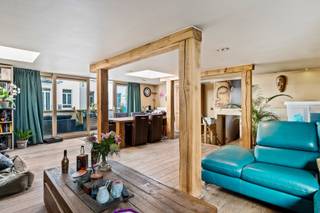 <p>Middenin het kloppende hart van ‘t historische Antwerpen bevindt zich dit indrukwekkende appartement. Met iconische hotspots zoals de Groenplaats, de Grote Markt en de Meir op slechts een steenworp afstand, geniet je hier dagelijks van de unieke charme en bruisende energie van de stad in al haar facetten.</p>
<p>Je komt binnen op de derde verdieping van dit mooi onderhouden gebouw, waar men vervolgens wordt verwelkomd in een praktische inkomhal met gastentoilet. Aansluitend heb je de riante leefruimte waar een warme, natuurlijke sfeer meteen voelbaar is dankzij de karakteristieke houten balken en prachtige planchervloeren. Bovendien staat deze ruimte in directe verbinding met het zonnige terras, een plek die ongetwijfeld uitnodigt om volop te genieten van de heerlijke buitenlucht. Verder heb je nog een moderne keuken welke werd uitgerust met een onderhoudsvriendelijke tegelvloer en hedendaagse toestellen, een perfecte combinatie tussen functionaliteit en comfort. Daarnaast beschikt dit appartement nog over een ruime slaapkamer van 17 m² met aangrenzend een badkamer met douche, handdoekradiator, lavabo in meubel en aansluitingen voor was- en droogmachine. Tot slot is er nog een royale mezzanine van 16 m², die perfect kan dienen als tweede slaapkamer. Deze verdieping beschikt eveneens over een ensuite badkamer met instapdouche, toilet en lavabo in meubel.</p>
<p>Dit is een buitenkans voor wie zoekt naar een combinatie tussen authenticiteit, licht, ruimte én een AAA-locatie, wellicht ben jij die persoon!</p>
<p><strong>Maandelijkse kosten: </strong>provisie van<strong> </strong>€ 176,30 (wordt per kwartaal opgevraagd) met een jaarlijkse afrekening (inclusief onderhoud van het gebouw, tuinen en lift, schoonmaak, water en elektriciteit gemene delen, syndicus.</p>
<p><strong>Technische gegevens: Lift aanwezig! </strong>Centrale verwarming op gas (individueel) via een condenserende ketel, HR-beglazing en dubbele beglazing in hout. <strong>Elektriciteit is conform! </strong></p>
<p><strong>Stedenbouwkundige inlichtingen en bodemattest aanwezig. Asbestveilig. Bevindt zich niet in een risicozone voor overstromingen (P- en G-score C). Renovatieverplichting niet van toepassing.</strong></p>