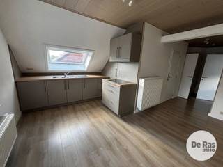ERONDEGEM - Knus dakappartement met autostaanplaats<br /><br />Inschrijven voor het geplande bezoekmoment kan via onze website => www.immoderas.be/afspraak-instructies<br /><br />Het appartement geniet een goede bereikbaarheid dankzij de nabijheid van belangrijke verbindingswegen richting Aalst en Gent, evenals openbaar vervoer op wandelafstand. In de directe omgeving bevinden zich diverse faciliteiten zoals lokale handelszaken, supermarkten, scholen en horecagelegenheden, wat bijdraagt aan een comfortabele en praktische woonomgeving.<br /><br />Het appartement beschikt over een inkomhal op de tweede verdieping. Via de trap bereikt men de derde verdieping, waar zich een volwaardige slaapkamer, een kleine kamer, een apart toilet en een badkamer bevinden. De badkamer is uitgerust met een douchecabine en wastafel.<br />Verder is er een open leefruimte met een geïntegreerde keuken, voorzien van een wastafel en keramische kookplaat. <br />Op de gelijkvloerse verdieping bevindt zich bovendien een praktische berging, ideaal voor het opbergen van fietsen, voorraad of andere spullen. Voor het gebouw is tevens een autostaanplaats inbegrepen.