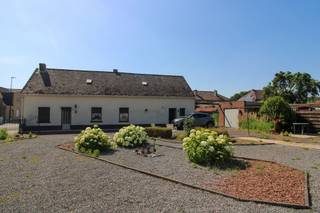 <p><span>Langs de Daalbroekstraat in Opgrimbie/Maasmechelen bevindt zich deze gelijkvloerse woning op een mooi perceel van maar liefst 8a50ca. De woning dateert vermoedelijk uit 1849 en biedt vandaag vooral een unieke opportuniteit voor wie op zoek is naar een renovatieproject of een interessante ontwikkelingsgrond.</span></p><p><span>De bestaande woning beschikt over een inkomhal, leefruimte, keuken, badkamer, berging en twee slaapkamers. Gezien de leeftijd en algemene staat van het gebouw dient rekening gehouden te worden met een grondige renovatie of sloop en heropbouw. Het pand beschikt momenteel over enkel glas, mazoutverwarming en een asbesthoudend dak. </span></p><p><span>Volgens het geldende zandlopermodel van de gemeente Maasmechelen biedt het perceel interessante perspectieven voor herontwikkeling. Onder voorbehoud van stedenbouwkundige goedkeuring en het bekomen van de nodige vergunningen lijkt het perceel potentieel te bieden voor de realisatie van twee halfopen bebouwingen. Ook twee open bebouwingen behoren mogelijk tot de opties, zij het met beperktere bouwmogelijkheden.</span></p><p><span>Dankzij de gunstige ligging, de ruime perceeloppervlakte en de ontwikkelingsmogelijkheden vormt dit eigendom een interessante kans voor projectontwikkelaars, investeerders of particulieren die hun droomwoning willen realiseren op een mooi stuk grond.</span></p><p><span> </span></p><p><span>Voor meer informatie of een bezoek ter plaatse, contacteer ons via 0484.35.70.31 of diana@jemar.be!</span></p>