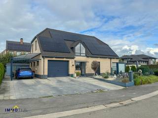 Het gelijkvloers omvat een inkomhal met gastentoilet, een zeer ruime en lichtrijke woonkamer met eetplaats en bureauruimte, volledig ingerichte...