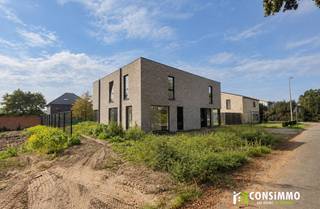 Modern wonen, energiezuinigheid en een hoogwaardige afwerking komen samen in deze halfopen nieuwbouwwoning in Oud-Termien. De woning maakt deel uit van een kleinschalig nieuwbouwproject bestaande uit twee halfopen woningen en bevindt zich momenteel in de afwerkingsfase. Bij de realisatie wordt bijzondere aandacht besteed aan duurzame materialen, hedendaagse technieken en optimaal wooncomfort.<br />Met een bruto bewoonbare oppervlakte van circa 140 m², drie slaapkamers, een perceel van 326 m² en een aangename zuidwestgerichte tuin biedt deze woning een mooie balans tussen ruimte, comfort en energiezuinig wonen. Een toekomstgerichte thuis op een rustige én strategische locatie in Genk.<br /><br /><strong>Indeling</strong><br />Via de inkomhal betreden we de woning en bereiken we de lichtrijke leefruimte. De open keuken met eethoek sluit naadloos aan op de woonkamer en vormt het centrale hart van de woning. Grote raampartijen zorgen voor een aangename natuurlijke lichtinval en versterken de verbinding met de achterliggende tuin.<br />Aansluitend aan de keuken bevindt zich een praktische berging, ideaal voor extra voorraad- en opslagruimte.<br /><br />Via de trappenhal bereiken we de verdieping, waar zich drie slaapkamers, de badkamer en een afzonderlijk toilet bevinden. De woning beschikt over een bruto bewoonbare oppervlakte van circa 140 m² en werd ontworpen met aandacht voor een praktische indeling en optimaal ruimtegebruik.<br /><br />Buiten beschikt de woning over een eigen oprit met parkeergelegenheid en een zuidwestgerichte achtertuin. Dankzij deze gunstige oriëntatie geniet u gedurende een groot deel van de dag en avond van de zon.<br /><br /><strong>Technische informatie</strong><br />Bij de realisatie van deze nieuwbouwwoning ligt de nadruk op energiezuinigheid, duurzaamheid en kwalitatief wooncomfort. De woning wordt hoogwaardig afgewerkt met duurzame materialen en voorzien van moderne technieken die bijdragen aan een laag energieverbruik.<br />De verwarming gebeurt via een energiezuinige warmtepomp in combinatie met vloerverwarming, wat zorgt voor een aangename en gelijkmatige warmteverdeling. Daarnaast wordt de woning voorzien van zonnepanelen, waarmee verder wordt ingezet op hernieuwbare energie en een laag energieverbruik. Ook is er reeds een aansluiting voor een laadpaal voorzien. De aluminium ramen met hoogrendementsbeglazing combineren een moderne uitstraling met uitstekende isolerende eigenschappen. Samen met de doorgedreven isolatie, zonnepanelen en energiezuinige technieken resulteert dit in een duurzame en toekomstgerichte nieuwbouwwoning met sterke energetische prestaties. E-peil E26.<br /><br /><strong>Buurtinformatie</strong><br />De woning bevindt zich in Oud-Termien, een rustige, groene en kindvriendelijke woonomgeving die tegelijk bijzonder strategisch gelegen is, op een boogscheutje van Genk-Centrum. Met De Maten en Bokrijk vlakbij liggen enkele van de mooiste natuur- en recreatiegebieden van de regio binnen handbereik. Ideaal voor wie graag wandelt, fietst of gewoon wil genieten van het groen. Tegelijkertijd bevinden scholen, winkels, supermarkten, openbaar vervoer en andere dagelijkse voorzieningen zich op korte afstand.<br /><br />Via de nabijgelegen Hasseltweg bereikt u vlot het uitgebreide commerciële aanbod in de omgeving. De Westerring zorgt bovendien voor een uitstekende verbinding richting Genk, Hasselt, Diepenbeek, Bilzen en Zutendaal, evenals naar de E314 en E313.<br /><br />Hier combineert u rustig en groen wonen met energiezuinige nieuwbouw, hedendaags comfort en een uitstekende bereikbaarheid.<br /><br />Ook de naastgelegen nieuwbouwwoning wordt te koop aangeboden. Informeer gerust bij ons kantoor naar de mogelijkheden.<br /><br />Deze hoogwaardige nieuwbouwwoning wordt aangeboden aan een verkoopprijs van € 465.000 exclusief btw.<br />Bij toepassing van 21% btw bedraagt de verkoopprijs € 562.650 inclusief btw.<br /><br />Bent u op zoek naar een duurzame en hoogwaardige nieuwbouwwoning met 3 slaapkamers en een zuidwestgerichte tuin op een strategische locatie? Contacteer ons via 089 69 30 01 of info@consimmo.be voor meer informatie of een bezoek ter plaatse. 