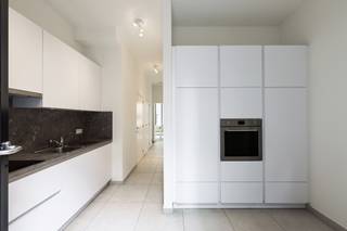 <p>Op een uiterst centrale ligging bevindt zich dit stijlvolle, volledig vernieuwde duplexappartement waar ruimte, licht en hedendaags wooncomfort perfect samenkomen. Dankzij de grote raampartijen geniet de leefruimte van een overvloed aan natuurlijk licht en een aangenaam open gevoel.<span></span></p>
<p>Via de lift bereikt u het appartement. De inkomhal met gastentoilet geeft toegang tot de ruime en lichtrijke leefruimte met een volledig ingerichte open keuken, afgewerkt met kwalitatieve materialen en voorzien van alle hedendaagse comfort. Vanuit de keuken heeft u rechtstreeks toegang tot een aangenaam terras, ideaal om buiten te genieten.</p>
<p>Verder beschikt het appartement over een praktische berging met aansluiting voor een was- en droogautomaat, evenals een aparte technische ruimte.</p>
<p>Via de trap bereikt u de bovenverdieping, waar zich twee ruime slaapkamers en een stijlvolle badkamer bevinden. Op deze verdieping is er bovendien toegang tot een tweede gezellig terras, waardoor u op elk moment van de dag van een buitenruimte kunt genieten.</p>
<p><strong> </strong></p>