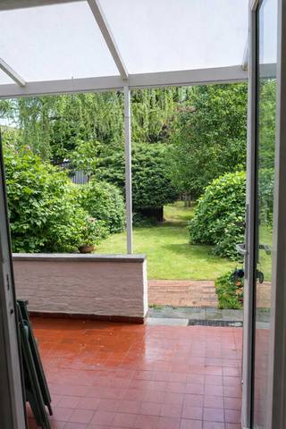 INSTAPKLAAR GELIJKVLOERSAPPARTEMENT – 1 SLAAPKAMER – GROENE STADSTUIN – OVERDEKT TERRAS – PRIVATE KELDER - GEEN SYNDICUS - RUSTIGE STRAAT - MOBISCORE 9,1<br />Ideaal voor alleenstaanden, koppels of starters<br /><br />Energiezuinig dankzij EPC C 265 kWh. <br /><br />Perceeloppervlakte : 196m² Bebouwde opp.: 73m³ Tuin en terras: 106m2<br /><br />Indeling:<br />Een centrale hall in het appartement geeft toegang tot de woonkamer, slaapkamer, keuken en wc met handwasser en douchecel.<br /><br />DE WOONKAMER (32 m2) met aangename lichtinval en laminaatvloer in goede staat, is vooraan gelegen en voorzien van PVC, dubbelglas en elektrische rolluiken.<br /><br />De zeer ruime, lichte en stille SLAAPKAMER ( 18 m2) met laminaatvloer, bevindt zich achteraan, tegen de tuin en heeft rolluiken. Ideaal bruikbaar als master bedroom of als combinatie van slaap- en werkruimte.<br /><br />DE KEUKEN ( 8.6 m2), eveneens aan tuinzijde is licht en voorzien van inbouwtoestellen (ijskast/diepvries, gasvuur met oven en dampkap). Er is ruimte en aansluiting voorzien voor wasmachine, droogkast en/of afwasmachine.<br /><br />De keuken geeft toegang tot een rustig, overdekt TERRAS (16 m2) met uitzicht op de rustige, groene tuin (90 m²).<br /><br />DE TUIN is zuid-oost georiënteerd, helemaal ommuurd, heeft een grasperk, is helemaal aangeplant en biedt de nodige privacy. Achteraan is er een bruikbaar tuinhuis. <br /><br />In elke ruimte van het appartement is centrale verwarming. De verwarming is individueel op gas via een hoogrendementsketel die in 2025 werd vernieuwd. Ook de elektriciteit in het appartement is conform het AREI.<br /><br />DE KELDER heeft een gemeenschappelijk deel waar alle nutsvoorzieningen zijn Er zijn 2 afsluitbare ruimtes , bruikbaar voor opslag, hobbyruimte met werkbank of voorraad.<br /><br />Het dak van het gebouw werd in 2006 conform de norm 2020 geïsoleerd.<br /><br />Geen syndicus en dus geen algemene kosten.<br /><br />