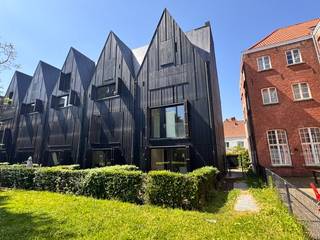 <strong>Instapklare stapelwoning met ruim zonneterras, garagebox en prachtige stadstuin in De Wispeltuin</strong><br /><br />In het prestigieuze woonproject <strong>De Wispeltuin</strong>, verscholen in een rustige zijstraat in het historische centrum van Brugge, bevindt zich deze stijlvolle stapelwoning die hedendaags wooncomfort combineert met rust, groen en een uitzonderlijke ligging.<br />De architectuur van het project springt onmiddellijk in het oog dankzij de eigentijdse vormgeving en hoogwaardige materialen. Achter de karaktervolle gevel schuilt een bijzonder aangename woonst met een doordachte indeling en veel natuurlijke lichtinval.<br /><br />Op het gelijkvloers bevinden zich de inkomhal met gastentoilet, een eerste slaapkamer, een praktische berging en een lichtrijke leefruimte die naadloos aansluit op de open keuken. De grote schuiframen zorgen voor een prachtig contact met buiten en geven rechtstreeks toegang tot het privatieve terras van ongeveer 30 m². Vanop het terras kijkt u uit op de prachtig aangelegde gemeenschappelijke tuin, een zeldzame luxe in hartje Brugge. De groene omgeving zorgt voor een oase van rust en privacy terwijl u toch op wandelafstand woont van de Markt, winkels, restaurants en openbaar vervoer.<br /><br />Via de trap bereikt u de bovenverdieping met een nachthal voorzien van ingebouwde opbergruimte en een tweede ruime slaapkamer. Aansluitend bevindt zich de badkamer uitgerust met douche, wastafelmeubel en toilet.<br />De woning beschikt bovendien over een <strong>gesloten garagebox</strong> en een <strong>privatieve kelderberging</strong> in de beveiligde ondergrondse parkeergarage.<br /><br /><strong>Troeven</strong><br />✓ Gelegen in het exclusieve woonproject De Wispeltuin<br />✓ Rustige ligging in het historische centrum van Brugge<br />✓ Ruim privatief terras van ca. 30 m²<br />✓ Uitzicht op prachtige gemeenschappelijke stadstuin<br />✓ Grote raampartijen en uitstekende lichtinval<br />✓ Moderne open keuken met berging<br />✓ 2 slaapkamers<br />✓ Ingebouwde opbergkasten<br />✓ Gesloten garagebox inbegrepen<br />✓ Privatieve kelderberging<br />✓ Beveiligde ondergrondse parking<br />✓ Instapklaar en perfect onderhouden<br /><br />Deze woning biedt een unieke woonervaring voor wie de charme van de Brugse binnenstad wil combineren met ruimte, comfort en een uitzonderlijke groene omgeving.<br /><br />Bovenop de huurprijs wordt een vaste onkostenvergoeding per maand aangerekend van 45 euro/maand.<br /><br />Meer info of een bezoek inplannen? Contacteer DRL VASTGOED, 050 65 95 95 of info@drlvastgoed.be<br /><br /> 