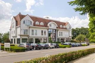 Op een toplocatie in Sint-Pieters-Leeuw bevindt zich dit uitzonderlijke penthouse met fantastische vergezichten over een natuurgebied en vijvers. Het penthouse met een hoge afwerkingsgraad werd afgewerkt met kwalitatieve materialen en maatwerk, waaronder parket, airconditioning, een centraal stofzuigsysteem en een zonnetenten.<br /><br />Het penthouse is als volgt ingedeeld: <br />Via de lift die gaat tot de private inkomhal, kom je terecht in de lichtrijke leefruimte met aparte tv-hoek, deze sluit via grote schuiframen naadloos aan op het ruime terras. De hypergeïnstalleerde keuken met aansluitende berging en wasruimte biedt alle hedendaags comfort. De master suite beschikt over een inloopdressing en een ensuite badkamer, terwijl de tweede slaapkamer een eigen douchekamer heeft. Een afzonderlijk bureau vervolledigt het gelijkvloerse woonniveau.<br /><br />Op de bovenverdieping bevindt zich een polyvalente ruimte die dienst kan doen als extra slaapkamer of bureauruimte, met berging en een indrukwekkend, rondom gelegen dakterras met buitendouche.<br /><br />Een extra troef is een afzonderlijke ruimte van 77 m² op het gelijkvloers. Deze ruimte biedt tal van mogelijkheden zoals een afzonderlijke kantoor- of praktijkruimte, een appartement voor een au-pair of als kangoeroewoning. Verder beschikt deze ruimte over zicht op de tuin, een eigen terras en een privatieve buitenparking. <br /><br />Tot slot beschikt deze unieke eigendom over een dubbele ondergrondse garage en drie private kelderbergingen, waaronder een wijnkelder.