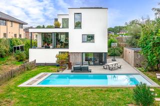 <p><strong>Energiezuinige villa met praktijk, zwembad, tuinkantoor en meer.</strong><br />Gelegen in een doodlopende straat met prachtig zicht, nabij invalswegen.</p>
<p>Deze grote woning garandeert alle hedendaags comfort in combinatie met ruimte voor vrije beroepers, kantoren en zelfs extra inwonenden/kangeroewonen op tuinniveau.<br /><br />Langs de straatzijde is de woning te bereiken via de voordeur, anderzijds is de praktijkruimte/burelen ook bereikbaar met extra toegangsdeur langs een mooi paadje.</p>
<p>De leefruimte is voorzien van grote eetplaats, een gezellige en toch ruim salon met houtkachel, prachtig zicht op tuin en de achtergelegen groenzone. Deze plaatsen geven elk uit op een leuk terrasje en de grote volledig geinstalleerde keuken met ontbijt-eethoek.<br /><br />De verdieping voorziet in een ruime hall met uitzicht, 3 ruime slaapkamers (op te splitsen tot 4 slaapkamers) waarbij master-bedroom met terras, plek voor dressing en eigen badkamer voorzien van wasmeubel en ligbad. Een aparte douchekamer en toilet is ook terug te vinden op deze etage.</p>
<p>Het souterrain, op tuinniveau is ingericht als praktijkruimte met eigen ingang, ideaal voor wie professionele activteiten en wonen wil combineren Er is een ontvangstruimte met toilet, twee burelen, waarvan één ingericht als medische praktijk aanwezig.<br /><br />Verder is op tuinniveau een grote technische berging terug te vinden en een polyvalente ruimte (sport-hobby-studio-atelier-andere) met douchehoek. Langs hier is er met schuiframen toegang tot het prachtige terras met zwembad (11 x 4.5m en vol-automatisch gestuurd).</p>
<p>De statige woning staat op een perceel van 14a 20ca dat werd aangelegd met aandacht voor natuurlijke vormen, flora en planten. <br /><br />Aan de voorgevel zijn 3 autostaanplaatsen (1x met laadpaal) en fietsenberging terug te vinden. In de achtertuin het prachtige zwembad, tuinhuis en een leuke groenzone als habitat voor gezin en (huis)dier met extra tuinkantoor (10m²) voorzien van elektriciteit, isolatie en mooie Thermowood afwerking.</p>
<p>Voor zij die wonen, werken en genieten wensen te combineren op een rustige locatie nabij invalswegen, faciliteiten en centrum Dilbeek, is deze energiebewuste en omvangrijke villa een kanshebber bij uitstek.<br /><br />EPC 86 kWh/(m²jaar) <br />Klasse A<br />Conforme elektrische keuring<br />Asbestveilig</p>