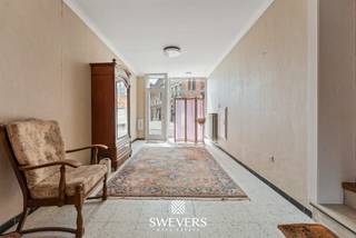 Voor meer info en foto’s, surf naar www.swevers.be – Aan Markt 1 in Tongeren-Borgloon bevindt zich dit karaktervolle herenhuis met maar liefst 346 m² bewoonbare oppervlakte. De woning dateert van voor 1850, kende tussen 2009 en 2013 reeds een grondige restauratiefase en biedt vandaag volop mogelijkheden voor een verdere renovatie naar eigen smaak. Op het gelijkvloers vind je ruime leefvertrekken met onder meer een living van 41,20 m², eetkamer van 13,32 m², keuken van 12,08 m² en berging. In totaal beschikt de woning over zes slaapkamers en drie wc’s, ideaal voor een groot gezin of wie extra kamers wenst voor thuiswerk, hobby’s of gasten. Ook aan bergruimte is er geen gebrek. De kelder meet 60,24 m² en de uitzonderlijk ruime zolder maar liefst 136 m², wat bijkomende mogelijkheden biedt mits de nodige vergunningen en technische haalbaarheid. Het perceel van 6 are omvat een noordelijk georiënteerde tuin en een garage. De centrale ligging is een extra troef: winkels, scholen, horeca, ontspanning en openbaar vervoer bevinden zich op korte afstand. Ook de fruitboomgaarden en het bekende doorkijkkerkje liggen vlakbij. Een bijzonder renovatieproject voor wie ruimte, karakter en een centrale ligging wil combineren.Voor meer informatie, bel 012 699 900. Bron bewoonbare oppervlakte: EPC –verslag. Dit pand is onderworpen aan de renovatieverplichting van de Vlaamse overheid voor residentiële gebouwen (behoudens bij sloop binnen 5 jaar na de aankoop). Consulteer voor meer informatie de website van het Vlaams Energie- en Klimaatagentschap via https://www.vlaanderen.be/een-huis-of-appartement-kopen/renovatieverplichting-voor-residentiele-gebouwen.