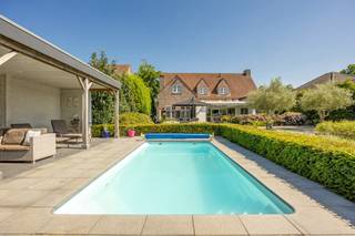<p>Palton troeven:<br />- Luxueuse Villa<br />- Energiezuinig (energielabel B!)<br />- Hoogwaardige afwerking<br />- Zonnepanelen ( 26 stuks)<br />- Verwarmd zwembad <br /><br />Welkom bij Steenweg Weelde 16 te Poppel! Hier vindt u deze schitterende villa op een perceel van circa 1.553 m². De woning is afgewerkt met hoogwaardige materialen en straalt een perfecte balans uit tussen modern comfort en stijlvolle elegantie. <br /><br /><span>Deze sfeervolle instapklare villa</span> verwelkomt u via een royale inkomhal met vestiaire en gastentoilet. Vanuit de hal heeft u directe toegang tot een <span>praktische kantoorruimte</span>, ideaal voor thuiswerk.</p>
<p>De leefruimte werd ontworpen met veel aandacht voor licht en openheid. Grote raampartijen zorgen voor een aangename connectie met de tuin. De gezellige zithoek vloeit mooi over in de eetkamer die centraal in de woning werd geplaatst en perfect geschikt is voor sfeervolle diners met familie en vrienden. Dankzij de brede schuiframen staan de leefruimte, de tuinkamer en het terras in directe verbinding met elkaar.</p>
<p>De royale leefkeuken is voorzien van kwalitatieve inbouwtoestellen. Door haar centrale ligging behoudt u vanuit de keuken een mooi zicht op zowel de voorzijde van de woning als op de tuin aan de achterzijde. Het ruime kookeiland vormt een gezellige ontmoetingsplek voor een ontbijt, een drankje of een ontspannen koffiemoment.</p>
<p>Grenzend aan de keuken bevindt zich een praktische bijkeuken met wasfaciliteiten en een directe doorgang naar zowel het terras als de ruime inpandige garage.</p>
<p>De tuinkamer vormt een aangename uitbreiding van de leefruimte en creëert een mooie overgang tussen binnen en buiten. Dankzij de heaters en de gashaard is deze ruimte het hele jaar door te gebruiken. Tijdens warme dagen kunnen de glazen wanden volledig geopend worden, zodat u optimaal van de tuin kunt genieten.</p>
<p>Op de eerste verdieping komt u uit bij de master bedroom, uitgerust met een ruime dressing en een luxueus ingerichte badkamer met douche, ligbad, dubbele wastafel verwerkt in meubilair en een afzonderlijk toilet.</p>
<p>Naast de hoofdslaapkamer beschikt deze villa over twee volwaardige, extra slaapkamers. Eén van deze kamers is momenteel ingericht als een gastenkamer met eigen badkamer.</p>
<p>Buiten wacht een oase van rust en ontspanning. De magnifieke tuin beschikt over een uitnodigend zwembad en een overdekt terras met bar. Een heerlijke plek voor lange zomeravonden. Het multifinctionele poolhousse maakt het plaatje compleet.</p>
<p>Achter op het perceel staat een vrijstaande carport met extra berging, een discrete stalruimte voor eventueel een camper of handige opslagruimte.<br /><br /><span>Kortom laat u betoveren door de charme en het comfort van deze instapklare villa.<br /></span><br /><span>Neem dan snel contact op via Judith@palton.be of bel naar +32492-78 31 74.</span></p>
<p></p>
