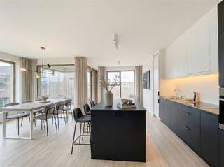 <p><span>Dit aangename appartement bevindt zich op de </span><span>5de verdieping</span><span> van een verzorgd gebouw met lift. Bij het binnenkomen kom je in een ruime inkomhal met een apart toilet en een moderne douchekamer, uitgerust met een dubbele lavabo. Het appartement beschikt over </span><span>twee volwaardige slaapkamers</span><span>.</span></p><p><span>Dankzij de </span><span>hoekligging</span><span> wordt de leefruimte omgeven door grote raampartijen, wat zorgt voor een overvloed aan natuurlijk licht en een open, aangenaam gevoel met een mooi uitzicht. De leefruimte sluit naadloos aan op de open keuken, die volledig is geïnstalleerd met moderne en energiezuinige toestellen, waaronder een efficiënte koel-vriescombinatie. Vanuit de leefruimte heb je directe toegang tot het </span><span>mooie terras</span><span>.</span></p><p><span>Het appartement wordt volledig geschilderd en voorzien van gordijnen &amp; verlichting. </span></p><p><span>Het appartement maakt deel uit van een </span><span>groene, bijna energieneutrale woonsite</span><span>, gelegen in een park met beschermd natuurgebied. Bovendien bevindt het zich op slechts </span><span>500 meter van het commerciële centrum van Wilrijk</span><span>. Antwerpen is vlot bereikbaar op tien minuten rijden, en ook de A12 en E19 richting Brussel liggen op slechts enkele minuten afstand. Er is een </span><span>fietsenstalling met oplaadpunten voor elektrische fietsen</span><span> voorzien.</span></p><p><span>Kosten:</span></p><ul><li><span>50,- euro  provisie voor verwarming</span></li><li><span>95,- euro vaste kosten (gebouwbeheer, onderhoud van de gemeenschappelijke delen, lift, elektriciteit van de gemeenschappelijke delen, enz.)</span></li></ul><p><span>Dit appartement is ideaal voor wie op zoek is naar modern wooncomfort in een groene en rustige omgeving, zonder in te boeten aan bereikbaarheid.</span></p><p><span>Interesse? Neem gerust contact op voor meer informatie of een bezichtiging.</span></p><p><span> </span></p><p><span> </span></p>