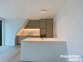 Dans le centre de Veldegem se trouve ce bel appartement avec deux chambres à coucher.<br /><br />Le hall d'entrée mène au séjour, où de grandes fenêtres constituent un atout majeur. De plus, les fenêtres sont équipées de stores électriques. La cuisine attenante est entièrement équipée avec des appareils SMEG, comprenant un lave-vaisselle, une plaque à induction avec hotte intégrée, un combiné réfrigérateur-congélateur et un four à chaleur tournante. À côté de la cuisine, une buanderie pratique dispose des raccordements pour une machine à laver et un sèche-linge.<br /><br />L'appartement comprend deux chambres, dont une avec une garde-robe intégrée. La salle de bain séparée est équipée d'une douche à l'italienne, d'un double lavabo, d'un meuble mural et d'un radiateur porte-serviettes.<br /><br />Grâce à sa situation au dernier étage, vous profitez d'une vue particulièrement belle depuis la grande terrasse.<br /><br />Le garage est inclus dans le prix de location et est doté d'une porte automatique, d'un éclairage et de l'électricité. Une station de recharge pour véhicules électriques peut également y être installée. Une deuxième place de garage peut être louée en option pour 75 € par mois. Les vélos peuvent être rangés en toute sécurité dans le local à vélos commun.<br /><br />L'appartement est déjà équipé de l'éclairage et de rails pour rideaux.<br /><br />Si vous souhaitez visiter ce bien, vous pouvez facilement réserver un rendez-vous via notre site web meuleman-loeters.be.