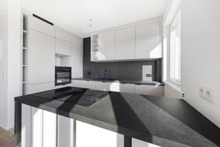 Welkom in de Raf Verhulstlaan 36-38, waar Immotrix met trots twee nieuw gerenoveerde appartementen op de tweede verdieping (ca. 100 m²) presenteert. Dit project overstijgt de standaard renovatie; het betreft een compromisloze, totale heropbouw met diep respect voor esthetiek, duurzaamheid en technische perfectie.
Vanaf de fundering tot de afwerking is werkelijk alles vernieuwd. Alle leidingen en de volledige elektriciteit zijn up-to-date en conform de strengste normen geplaatst. Dankzij een doorgedreven, hoogwaardige isolatiestrategie genieten deze appartementen van een zeldzaam en toekomstgericht EPC B-label — uw garantie op een zorgeloze en energiezuinige toekomst.
Bij het betreden van het appartement valt direct de indrukwekkende lichtinval op. De royale raampartijen aan de voorzijde laten het daglicht vloeiend weerspiegelen op de strakke vloerafwerking. De leefruimte loopt naadloos over in een hypermoderne leefkeuken. Deze blikvanger is uitgerust met een monumentaal kookeiland in een verfijnde, donkere natuursteenlook en afgewerkt met greeploze, gelaagde witte fronten en premium matzwarte kranen en details.
De badkamer ademt de sfeer van een high-end boetiekhotel. Dankzij de warme tonen het design-maatwerk, kamerhoge keramische tegels in een zachte zandkleur en een luxueuze inloopdouche met een minimalistische glazen wand, geniet u hier dagelijks van puur wellnesscomfort.
Het nachtgedeelte is doordacht ingedeeld en beschikt over twee volwaardige, rustgevende slaapkamers waarvan 1 met toegang naar het zonovergoten terras. Daarnaast herbergen deze appartementen een architecturaal geheim: een ruime, multifunctionele flex-room. Hoewel deze kamer bewust zonder buitenraam is ontworpen om een intieme en serene sfeer te waarborgen, biedt de ruimte een ongeziene flexibiliteit. Door de perfecte visuele en akoestische afzondering leent deze kamer zich uitstekend als een exclusieve walk-in dressing, een inspirerende en stille thuiswerkplek (home office), of een geborgen, fluisterstille babykamer. Een appartement op de 2de verdieping is momenteel verhuurd aan 1.175 € per maand wat dit object ook tot een interessante investeringsopportuniteit maakt.
Wonen in Wommelgem betekent hier: intrekken zonder toegevingen, omringd door tijdloze esthetiek, modern comfort en een ongeëvenaard afwerkingsniveau. Een unieke kans voor wie op zoek is naar een instapklaar, turn-key droomappartement op een strategische locatie. Contacteer Immotrix voor uw exclusieve bezichtiging.