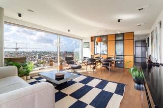 Prachtig hoekappartement op de 18de verdieping van de Antwerp Tower.<br />Wonen in het hoogste residentiële gebouw van de stad, op een toplocatie naast het Operahuis en op wandelafstand van het Centraal Station, de Meir, toprestaurants en tal van winkels.<br />Indrukwekkend uitzicht over de stad vanuit elke ruimte van het appartement.<br /><br />Mooie leefruimte met veel lichtinval door de uitzonderlijk grote raampartijen en de mooie eiken parketvloer.<br />Aansluitend een groot, zuidwestgericht zonneterras met adembenemend uitzicht.<br /><br />De keuken is volledig uitgerust met hypermoderne toestellen van V-ZUG, zoals een stoomoven, warmhoudlade, vacuümmachine en een Quooker-kraan.<br />Mooi afgewerkt keukeneiland met een Dekton werkblad.<br /><br />Vervolgens is er de masterslaapkamer met prachtig uitzicht en een aansluitende dressing, waarin een Samsung Airdresser aanwezig is.<br />Apart Japans toilet en een mooi afgewerkte badkamer met grote lavabo en inloopdouche.<br /><br />Door de indrukwekkende inkomhal van het gebouw en de aanwezigheid van een conciërge (24/7) krijg je het echte New York style-gevoel in Antwerpen.<br /><br />Het appartement is volledig tot in de puntjes afgewerkt en ingericht door de gerenommeerde HvH-architecten.<br /><br />Afzonderlijk aan te kopen:<br />– Ondergrondse autostaanplaats: €40.000<br />– Extra bergruimte op de verdieping: €10.000