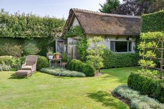 <p>Op een gegeerde locatie in De Sterre te Kapellen bevindt zich deze bijzonder charmante woning met rieten dak, een warme uitstraling en een verzorgde afwerking.</p>
<p>Via de inkomhal met vestiairekast komt u in de open leefruimte op eiken parket, waar de open haard meteen voor sfeer zorgt. Grote raampartijen brengen veel natuurlijk licht binnen en zorgen voor een aangename verbinding met de tuin. Aansluitend bevindt zich de open keuken, eveneens afgewerkt in eik en voorzien van een natuurstenen werkblad en AGA-fornuis. Vanuit de leefruimte en keuken is er rechtstreekse toegang tot het terras en de mooi aangelegde tuin.</p>
<p>Verder beschikt de woning over een praktische wasberging, een afzonderlijk toilet met handenwasser en een kelder.</p>
<p>Op de eerste verdieping geeft de ruime overloop op parket toegang tot twee volwaardige slaapkamers, voorzien van op maat gemaakte ingebouwde eiken kasten. Daarnaast is er een derde kamer die perfect dienst kan doen als slaapkamer, bureau of hobbyruimte.</p>
<p>De badkamer is uitgerust met een dubbele lavabo, een ruime inloopdouche en toilet. Daarnaast is er een zolder aanwezig die extra bergruimte biedt.</p>
<p>Een absolute troef is het volledig ingerichte bijgebouw achteraan in de tuin. Deze voormalige garage werd omgevormd tot een volwaardige multifunctionele ruimte en beschikt over veel natuurlijk licht, een pelletkachel en een mezzanine. Ideaal als bureau, atelier, hobbyruimte of extra verblijfsruimte.</p>
<p>De woning beschikt volgens het EPC over een bruikbare vloeroppervlakte van 138 m². Daarnaast biedt het ingerichte bijgebouw circa 28 m² extra gebruiksruimte. De kelder en zolder zijn niet inbegrepen in deze opgegeven oppervlaktes. Door de specifieke EPC-meetmethode wordt op de eerste verdieping bovendien enkel de oppervlakte vanaf 1,50 m vrije hoogte meegerekend.</p>
<p>De groene, verzorgde tuin met verschillende sfeervolle hoekjes vormt een mooi geheel met de woning en biedt veel privacy.</p>
<p>Een charmante en bijzonder verzorgde woning met kwalitatieve materialen en een uitstekende ligging in Kapellen. Ideaal voor wie op zoek is naar charme, rust en een woning met nét dat beetje extra.</p>
<p>De Valkenlaan, gelegen in de gegeerde wijk “De Sterre” in Kapellen, bevindt zich in een rustige en groene woonomgeving. De woning is gelegen op een mooi perceel van 615 m², omgeven door volwassen groen en met voldoende privacy. “De Sterre” staat gekend om haar residentiële karakter, groene lanen en aangename woonkwaliteit. Hier woont u rustig en beschut, terwijl het centrum van Kapellen en alle dagelijkse voorzieningen vlot bereikbaar blijven. Dankzij de centrale ligging tussen Kapellen en Brasschaat bevinden scholen, winkels, horeca, sportfaciliteiten en openbaar vervoer zich op korte afstand. Ook de belangrijkste verbindingswegen richting Antwerpen en de omliggende gemeenten zijn eenvoudig bereikbaar. De combinatie van een groene, rustige omgeving en een goede bereikbaarheid maakt de Valkenlaan tot een bijzonder aangename woonlocatie voor wie comfortabel en residentieel wil wonen in Kapellen.</p>
<p><br /><br /><br /></p>