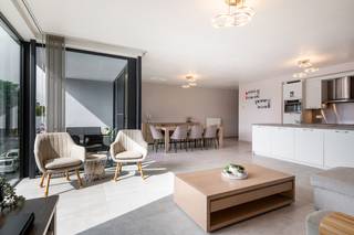 Ruim appartement van 119,5m² met achterliggende garage in hartje Schoten. Het appartement biedt uiterst veel licht door de grote glaspartijen en de gevelbreedte. Inkomhal, woonkamer aan open keuken met kookeiland en ruime berging, toegang naar overdekt terras, badkamer (ruime inloopdouche en dubbele wastafel), apart toilet, 3 slaapkamers en terras over volle breedte. Extra's: achterliggende garage inbegrepen, kelderberging, gemeenschappelijke fietsenberging. Gemeenschappelijke bijdrage 70 Euro per maand.