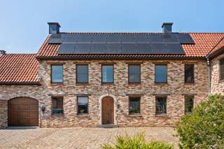 Ruim karakteristiek huis met 4 slaapkamers, een grote tuin en authentieke charme. Dit uitzonderlijke pand combineert de charme van een authentieke kleine boerderij met het comfort van een recente uitbreiding uit 2013. Met een woonoppervlakte van maar liefst 522 m² (te verifiëren aan de hand van het PEP), een perceel van 1 726 m² en een veelzijdige indeling is dit huis ideaal voor grote gezinnen, zelfstandigen of mensen die op zoek zijn naar een unieke woonervaring met veel ruimte.Indeling: entreehal, kantoor, apart gastentoilet, een grote, lichte woonkamer, een kantoor met mezzanine, bijkeuken/wasruimte, badkamer, keuken en een tweede gezellige woonkamer. Dankzij de praktische indeling is het bovendien mogelijk om op de begane grond een slaapkamer in te richten.Op de eerste verdieping bevinden zich vier ruime slaapkamers, een tweede badkamer, een wellnessruimte met infraroodsauna, een inloopkast, een terras grenzend aan de ouderslaapkamer en een bibliotheek/kantoor. Daarnaast beschikt het huis over een ruime en volledig geïsoleerde zolder, ideaal als extra opslagruimte.Buiten kunt u genieten van een prachtige tuin met verschillende terrassen en een eigen boomgaard met onder andere vijgen-, appel-, kersen-, perzik- en pruimenbomen. Het huis beschikt tevens over een garage en een ruime parkeerplaats die plaats biedt aan meerdere auto’s.Het oorspronkelijke linkergedeelte van het huis heeft zijn authentieke karakter behouden, terwijl het rechtergedeelte in 2013 volledig is herbouwd en zowel op de begane grond als op de eerste verdieping is voorzien van vloerverwarming op aardgas. De hoofdslaapkamer en de bibliotheek zijn voorzien van airconditioning.Het huis straalt veel karakter uit dankzij de hoogwaardige en unieke afwerking, met onder meer prachtige binnendeuren vervaardigd uit deuren afkomstig van Indiase tempels en een gevarieerde keuze aan materialen zoals travertijn in de inkomhal, parket, leisteen in het kantoor, blauwe hardsteen aan de buitenkant en karaktervolle kasteeltegels in de tweede zitkamer. Bovendien zorgen de geïnstalleerde zonnepanelen voor een meerwaarde op het vlak van energie-efficiëntie. Te koop via Immo Beguin, uw vastgoedexpert sinds 2009.Meer informatie of een bezichtiging? Neem contact op met emmy@immobeguin.be