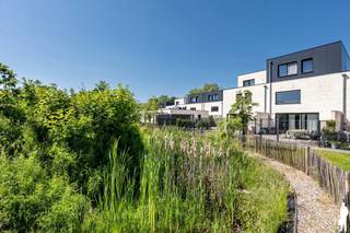 <strong>Op zoek naar een moderne woning waar je zonder verbouwen kunt intrekken, maar waar je terzelfdertijd niet elk weekend je vrije tijd aan groenonderhoud wilt besteden? Deze recente woning in het groene en ruime woonerf 'Klein Dorlick' combineert comfortabel en energiezuinig wonen met de nabijheid van Hasselt-centrum.<br /><br />De woning werd gebouwd in 2022 en beschikt over een uitzonderlijk EPC van slechts 4 kWh/m²/jaar. Dankzij onder meer vloerverwarming, zonnepanelen, ventilatiesysteem D en moderne woningtechnieken geniet je van hedendaags comfort met een bijzonder laag energieverbruik.<br /><br />Met drie slaapkamers biedt de woning bovendien de nodige flexibiliteit voor een gezin, thuiskantoor, hobbyruimte of logeerkamer. Het zuidgerichte terras en de groene omgeving zorgen voor aangename buitenruimte, terwijl een eigen parkeerplaats met laadpaalmogelijkheden (aansluiting reeds aanwezig) het dagelijkse comfort compleet maakt.<br /><br />Een ideale woning voor wie modern, energiezuinig en onderhoudsarm wil wonen, met Hasselt-centrum binnen handbereik<br /><br />De buurt en ruimere omgeving staan bekend om hun groene, rustige en autoluwe karakter én uitstekende verbinding naar zowel Hasselt-centrum, de autosnelweg (E313) als de groene omgeving richting Diepenbeek. De riante omliggende groenzone ter plaatse is voor bewoners toegankelijk en biedt vele zonnehoeken, schaduwzones, fietsenberging en pleintjes.<br /><br /></strong><span>Gelijkvloerse verdieping:</span><br />Via de inkomhal met vestiare en gastentoilet heeft u toegang tot de woonkamer. Deze leefruimte is voorzien van een gezellige zit-/tv-hoek en loopt door naar de open keuken. Deze leefruimte geniet bovendien van enorm veel natuurlijk daglicht door de riante raampartijen.<br /><br />De keuken is luxueus geïnstalleerd en volledig voorzien. Zij biedt o.a. een afzonderlijke, ruime koelkast, een aparte, grote diepvrieskast (beiden Zanussi), een Samsung vaatwasser met besteklade, een combi-oven (Zanussi) en een inductiekookplaat met ingebouwd afzuigsysteem (Novy). Er is een riant kookeiland aanwezig met legio werkruimte en waar u bovendien kan genieten van een ochtendkoffie en/of een glas wijn met vrienden of familie.<br /><br />Aan de keuken bevindt zich de berging en een technische ruimte waar er voorzieningen zijn voor wasmachineaansluiting, alsook de CV-ketel (gaswandketel van kwaliteitsmerk Vaillant).<br /><br /><span>Eerste verdieping:</span><br />De vaste houten trap in de woonkamer brengt u naar de eerste verdieping. Hier bevinden zich 3 ruime slaapkamers, een toiletruimte en een badkamer met inloopdouche, badkamermeubel en lavabo. De meeste ramen in de slaapkamers zijn op afstand te verduisteren. Voorziening om alle ramen te verduisteren met domotica is aanwezig. In de badkamer is afzonderlijke ventilatie voorzien (eveneens domotica).<br /><br /><span>Buitengebeuren:</span><br />De woning heeft een gezellig, zuidgeoriënteerd terras en parking (1 standplaats) is inbegrepen. Er zijn voorzieningen aanwezig voor het plaatsen van een zonneluifel aan de achtergevel. Verder is er een riante gemeenschappelijke tuin die enkel toegankelijk is voor de bewoners-eigenaars van het woonerf.<br /><br /><span>Bijzonderheden:</span><br />- <strong>12 zonnepanelen </strong>(3,3 kWp)<br />- EPC van <strong>4 kWh/m²/jaar </strong>ofwel <strong>label A</strong><br />- Volledig <strong>vloerverwarming én domotica<br />- </strong>Gemeenschappelijke kosten van <strong>40 euro/maand</strong><br />- Rustige ligging <strong>nabij groen</strong> / natuur en <strong>centrum Hasselt</strong><br />- Eigen <strong>parkeerplaats </strong>(inbegrepen in vraagprijs) en <strong>bijkomende parkeermogelijkheden</strong><br />- Mooi, <strong>eigen terras</strong> op het <strong>zuiden </strong>alsook een riante gemeenschappelijke natuurtuin