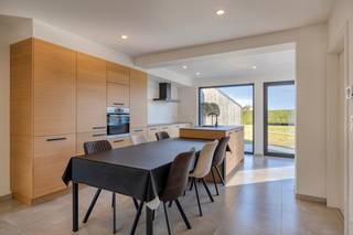 <h3>Instapklare gezinswoning met ruime opslagplaats en zuidoostgerichte tuin</h3>
<p>Deze recent gerenoveerde woning (2020-2021) combineert hedendaags wooncomfort met verrassend veel ruimte, zowel binnen als buiten. Dankzij de gunstige ligging nabij het centrum, scholen en de E34 geniet u hier van een vlotte bereikbaarheid en alle voorzieningen binnen handbereik.</p>
<p>Via de inkomhal met gastentoilet betreedt u de lichtrijke leefruimte. De gezellige zithoek, eetplaats en volledig uitgeruste leefkeuken vormen samen het hart van de woning. De keuken beschikt over een kookeiland, oven, vaatwasser, inductiekookplaat, dampkap en ruime koelkast. Aansluitend bevindt zich een aangename ontbijthoek met schuifraam naar het terras en de tuin.</p>
<p>Op het gelijkvloers vindt u daarnaast een praktische berging met ingemaakte kasten, uitgietbak, voorzieningen voor wasmachine en droogkast en toegang tot de droge kelder.</p>
<p>De eerste verdieping omvat drie slaapkamers. De ruime masterbedroom beschikt over ingemaakte kasten en directe toegang tot de badkamer, uitgerust met een dubbel lavabomeubel, inloopdouche en tweede toilet. Verder zijn er nog twee bijkomende slaapkamers. Vanuit één van deze kamers bereikt u via een vaste trap de geïsoleerde zolderverdieping.</p>
<p>Buiten geniet u van een onderhoudsvriendelijke, zuidoostgerichte tuin met een uitzonderlijk ruime opslagplaats van ca. 59 m² (6,20 m x 9,59 m) en een nokhoogte van 4,15 m. Ideaal voor zelfstandigen, hobbyisten of wie extra bergruimte zoekt.</p>
<p><strong>Troeven:</strong></p>
<ul>
<li>Recent gerenoveerd (2020-2021)</li>
<li>3 slaapkamers</li>
<li>EPC B (174 kWh/m² jaar) - zonnepanelen nog niet mee in rekening</li>
<li>12 zonnepanelen</li>
<li>CV op aardgas</li>
<li>Regenwaterput met pomp</li>
<li>Ruime opslagplaats/bijgebouw van ca. 59 m²</li>
<li>Poort aanwezig</li>
<li>Zuidoostgerichte tuin</li>
<li>Goede ligging nabij centrum, scholen en E34</li>
</ul>