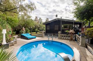 <p><span>De chalet is gelegen in het groene en bosrijke recreatiepark Tulderbos, een rustige omgeving waar natuur en ontspanning centraal staan. De chalet bevindt zich vlak bij de Nederlandse grens, waardoor ook Nederland en de omliggende Nederlandse gemeenten gemakkelijk bereikbaar zijn. In de omgeving zijn er volop mogelijkheden om te wandelen en te fietsen. <br /></span><br />De chalet is gelegen aan de bosrand in de uiterste hoek van het park op een dubbel perceel van 528m².<br />De chalet heeft 2 slaapkamers, badkamer, ingerichte keuken en een aangename tuin en diverse terrassen.<br />Er zijn meerdere bijgebouwen waaronder een gezellige bar met zwembad.<br /><br />De chalet is voorzien van 2 slaapkamers, badkamer met dubbele wastafel en douche, apart toilet, open keuken met inbouwapparatuur grenzend aan de gezellige woonkamer met houtkachel. schuifdeuren naar het zonnige terras.<br /><br />Bijgebouw met de mogelijkheid voor een 3de kamer en elec. aansluitingen.<br />Bijgebouw, momenteel in gebruik als ingerichte bar.<br />Zwembad en siervijver op het perceel.<br /><br />Bijzonderheden:<br />- Gelegen in de hoek van het park, zeer rustig aan de bosrand.<br />- Centrale verwarming op propaangas (ketel 2017)<br />- Staande op 2 bouwpercelen<br />- Dubbel glas<br />- airco<br />- zonnepanelen<br />- tuin volledig omheind<br />- Voldoende parkeermogelijkheden op eigen terrein.<br />- Gelegen in recreatiepark, permanente bewoning is officieel niet toegestaan maar wordt gedoogd door de gemeente Ravels.<br /><b>Let op: Voor de aankoop dient u circa 50% aan eigen geld te hebben aangezien de Belgische bank maar tot +/- 50% van de aankoopprijs financiert. </b><br /><br /></p>