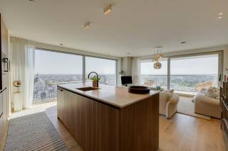 Gelegen in het hart van Antwerpen, aan de De Keyserlei, bevindt zich de iconische Antwerp Tower. Vanuit deze centrale locatie bevinden de Meir, de historische binnenstad, de Opera en het Centraal Station zich op wandelafstand. De Antwerp Tower combineert een bruisende stadsomgeving met een uitzonderlijk wooncomfort en biedt vanuit de hogere verdiepingen een uniek perspectief over de stad.<br /><br />Dit luxueuze appartement op de 19de verdieping, werd stijlvol ingericht door een interieurarchitect en wordt gekenmerkt door zijn panoramische zichten over Antwerpen en een hoogwaardige afwerking. De inkomhal verwelkomt u met ingemaakte kasten en een gastentoilet en beschikt daarnaast over een praktische berging met aansluitingen voor wasmachine en droogkast.<br /><br />Het kloppende hart van het appartement wordt gevormd door de ruime leefruimte met open keuken voorzien van een ruim eiland. Grote raampartijen zorgen hier voor een overvloed aan natuurlijk licht en panoramische vergezichten over de stad. De open keuken vormt een elegant geheel met de zit- en eetruimte en werd uitgerust met kwalitatieve inbouwtoestellen. De mooie parketvloer zorgt voor een warme en stijlvolle uitstraling. Bovendien heeft u hier rechtstreeks toegang tot het zonnige terras, waar u in alle rust kan genieten van de weidse zichten over Antwerpen. Dankzij de aanwezige zonnewering en het ventilatiesysteem type D wordt bovendien ingezet op een aangenaam binnenklimaat en toekomstgericht wooncomfort.<br /><br />De masterbedroom beschikt over ingemaakte kasten en een ensuite badkamer, afgewerkt met hoogwaardige materialen en voorzien van een dubbele wastafel, ruime inloopdouche en toilet. De tweede slaapkamer kan, afhankelijk van uw wensen, eveneens dienstdoen als bureau of multifunctionele ruimte. Beide kamers genieten dankzij hun ligging ook van prachtige zichten over de stad. Een tweede badkamer, uitgerust met een inloopdouche en wastafel, vervolledigt het slaapgedeelte.<br /><br />Tot slot is er een praktische kelderberging, inbegrepen in de prijs. Een ondergrondse garagebox kan bij aangekocht worden voor 65.000 EUR. <br /><br />Wilt u hier binnenkort zelf genieten van deze vergezichten over Antwerpen? Contacteer LISTED voor een bezoek: +32 3 283 51 51.
