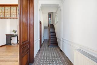 <p>Located in the heart of Edegem, within walking distance of the market square, shops, schools and beautiful parks, this unique townhouse perfectly combines timeless character with modern living comfort. Behind its elegant façade lies a home that has been meticulously renovated with great care and respect for its authentic features.</p><p>Original details such as the beautiful solid wood parquet floors, high ceilings, elegant interior doors, stained glass windows and charming original fireplaces create a warm and refined atmosphere. At the same time, the property offers every modern convenience, including central heating, new double-glazed windows and a high-quality finish throughout.</p><p>A tasteful rear extension has created a bright and inviting dining area that flows seamlessly into the kitchen while overlooking the exceptionally deep garden. A rare asset for such a central location, offering the perfect balance of privacy, tranquillity and greenery.</p><p>The property is equally practical, featuring a private driveway, a spacious garage and a full basement providing ample storage space. Additional parking is readily available in the immediate vicinity.</p><p>The first floor offers two generously sized bedrooms, each retaining its original fireplace, adding to the home's distinctive charm. This level also features a stylishly renovated bathroom with both a bathtub and walk-in shower, as well as a separate laundry room.</p><p>The second floor comprises three additional full-sized bedrooms, ideal for family living, a home office, guest accommodation or hobby space. Thanks to its generous proportions and well-designed layout, this home offers exceptional flexibility without compromising its authentic character.</p><p>This remarkable townhouse is a rare combination of historic elegance, contemporary comfort and an outstanding central location. A home with true character, where timeless architectural features and modern living blend seamlessly, offering a unique opportunity to enjoy one of Edegem's most desirable addresses.</p>