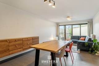 Voor meer info en foto’s, surf naar www.swevers.be – Aan de Luikersteenweg 324 in Hasselt vindt u dit instapklare gelijkvloerse appartement met één slaapkamer, privatieve staanplaats en een ruim terras met achterliggend groen. Het appartement maakt deel uit van een kleinschalig gebouw met slechts vier entiteiten, wat zorgt voor beperkte gemeenschappelijke kosten en een aangename woonomgeving.<br />Met een bewoonbare oppervlakte van 72 m² biedt dit appartement een praktische en lichtrijke indeling. De leefruimte van ca. 26,5 m² vormt het hart van de woning en geniet dankzij de grote raampartij van veel natuurlijk licht en zicht op het terras en het achterliggende groen.<br />Aansluitend bevindt zich de functionele keuken. Verder beschikt het appartement over een ruime slaapkamer van ca. 16 m², een aangename badkamer, een aparte berging en een afzonderlijk toilet. Het terras van 16 m² is een grote troef: hier geniet u volop van de rust en privacy. Het privatief gebruik van een stukje achterliggende tuin is bovendien bespreekbaar. Ook qua comfort zit u goed dankzij de gascondensatieketel en Daikin Perfera lucht-lucht warmtepompen, die zorgen voor energiezuinige verwarming en verkoeling. Winkels liggen op wandelafstand, openbaar vervoer op 120 meter en de E313 op korte afstand. Een ideale kans voor starters, alleenstaanden of investeerders die comfortabel en centraal willen wonen in Hasselt. Voor meer informatie, bel 011 255 155. Bron bewoonbare oppervlakte: EPC – verslag.