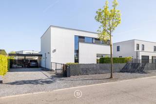 Architecture contemporaine en béton, conçue par Nano Architecten, dans un emplacement exceptionnel près des étangs de Borggraeve et de Bokrijk.<br /><br />À distance de vélo du centre-ville de Hasselt se trouve cette élégante maison familiale où l'architecture contemporaine, la finition de haute qualité et le confort de vie durable se renforcent mutuellement sans effort. La villa, construite en béton et conçue par Nano Architecten, se distingue par ses lignes pures, son agencement réfléchi et son allure intemporelle.<br /><br />De grandes baies vitrées laissent entrer abondamment la lumière du jour et créent un lien constant avec le jardin. La mezzanine renforce la sensation d'espace et de lumière, donnant à chaque pièce de vie une atmosphère ouverte et sereine.<br /><br />L'ensemble est naturel et cohérent, une maison qui répond aux besoins d'aujourd'hui et conserve sa qualité à long terme. La technique de construction derrière cette réalisation contribue à cette certitude : une manière réfléchie de construire qui associe la liberté architecturale à la stabilité, au confort et à de hautes performances énergétiques.<br /><br />Le cœur de la maison est formé par la luxueuse cuisine ouverte avec îlot de cuisson, finie avec des matériaux de qualité et équipée d'appareils électroménagers haut de gamme. Une buanderie pratique se trouve à côté, discrètement intégrée derrière un placard sur mesure, préservant ainsi l'architecture épurée.<br /><br />L'étage comprend trois chambres, une grande salle de bains avec douche à l'italienne, des espaces de rangement supplémentaires et un confortable espace bureau ouvert qui répond parfaitement aux besoins de vie contemporains.<br /><br />Le jardin entièrement aménagé comprend une terrasse partiellement couverte, un abri de jardin et un carport pour deux voitures avec borne de recharge intégrée.<br /><br />Grâce à la combinaison de panneaux solaires, d'une batterie domestique et d'une pompe à chaleur, la maison bénéficie également d'excellentes performances énergétiques.<br /><br />Une villa prête à emménager où l'architecture raffinée, les techniques durables et un emplacement exceptionnel se combinent pour offrir une expérience de vie de haut niveau.