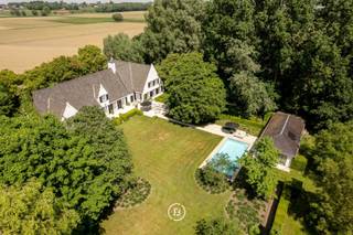 Gelegen op een uitgestrekt perceel van 8.679 m² nabij Kortrijk, bevindt zich een exclusief domein met een ruim zwembad en poolhouse.Deze eigendom...