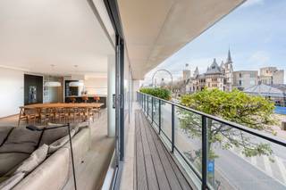 ANVERS - Appartement exclusif et lumineux avec vue panoramique sur les quais<br /><br />Cet appartement particulièrement spacieux d'environ 200 m² est situé au premier étage d'une résidence contemporaine sur le Jordaenskaai, juste en face de l'emblématique Steen et de l'Escaut. Grâce aux grandes baies vitrées qui l'entourent, vous bénéficiez ici d'une luminosité exceptionnelle et d'une expérience de vie ouverte que l'on trouve rarement dans le centre-ville.<br /><br />L'espace de vie s'étend sur toute la largeur de la façade et offre une vue impressionnante sur les quais. La salle à manger et le coin salon s'intègrent parfaitement à la cuisine ouverte haut de gamme, équipée notamment d'un îlot de cuisson, d'une cave à vin et de solutions de rangement spacieuses. L'ensemble respire la tranquillité, la simplicité et la qualité, un aménagement intemporel qui met en valeur tous les styles d'intérieur.<br /><br />La grande terrasse à l'avant, qui s'étend tout autour des façades gauche et droite, constitue un atout important. Elle crée un espace extérieur unique qui bénéficie du soleil du matin et du soir, idéal pour ceux qui aiment l'ouverture, la vue et un lien direct avec la ville.<br /><br />L'appartement dispose également de deux chambres à coucher à part entière, chacune avec salle de bains attenante. La chambre principale est équipée d'armoires encastrées, d'un dressing attenant et d'une salle de bains moderne avec baignoire et douche. La deuxième chambre dispose de ses propres sanitaires et offre une intimité supplémentaire pour les invités ou un bureau à domicile. À l'arrière, il y a également une deuxième terrasse urbaine plus intime.<br /><br />Le confort pratique est également garanti : chauffage au sol, matériaux haut de gamme, espace de rangement suffisant et agencement bien pensé en font un ensemble extrêmement fonctionnel.<br /><br />Une place de parking est incluse dans le garage souterrain, ce qui constitue une valeur ajoutée indéniable dans cet emplacement.<br /><br />Cet appartement combine des volumes généreux, un emplacement prestigieux et des finitions raffinées pour offrir un ensemble exceptionnel à ceux qui recherchent le calme, la lumière et le confort au cœur d'Anvers.<br /><br />Place de parking + cave de rangement incluses.<br />