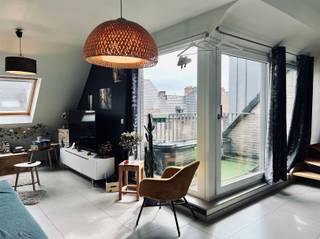 Dit duplex appartement is gelegen op de tweede verdieping in het centrum van Vrasene. U beschikt over een terras en een achterliggende garagebox.U betreedt het appartementencomplex via de algemene inkomhal, zowel via de lift als via de trap bereikt u de inkomdeur van het appartement. De indeling van het appartement is als volgt: U betreedt het appartement via de inkomhal met apart toilet. Verder door is er de lichtrijke eetruimte, open ingerichte keuken met aansluitend de berging en living met toegang tot het terras. Verder heeft u één slaapkamer en een badkamer, voorzien van ligbad met douchefunctie en dubbele lavabo met lavabomeubel. Via de houten trap bereikt u de bovenste verdieping, waar u meteen terechtkomt in een grote open polyvalente ruimte (kan volledig ingericht worden naar wens) en een tweede zeer ruime slaapkamer. Nog enkele troeven van dit appartement: centrale verwarming op aardgas, instapklaar, veel lichtinval, achterliggende garagebox aan € 50,00/maand (verplicht), mogelijkheid tot huren van extra autostaanplaats achteraan (€30/maand), geen algemene kosten, laag E-peil en het appartement is vrij vanaf 1 oktober 2026.Interesse? Aarzel zeker niet om ons vrijblijvend te contacteren en mail naar verhuur@bebuild.be