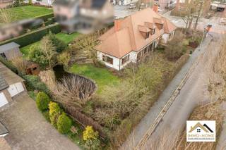 Deze stijlvolle villa bevindt zich in het groene Merelbeke. Je komt binnen via een ruime, elegante traphal die toegang biedt tot alle vertrekken op het gelijkvloers. Aan de voorzijde bevindt zich een zeer ruim bureau, ideaal voor thuiswerk of praktijkruimte. Verder is er een apart gastentoilet en een vlotte doorgang naar de leefruimtes. De volledig ingerichte keuken is uitgerust met een grote eethoek en kamerhoge ramen die zorgen voor overvloedig daglicht en een directe verbinding met de tuin. Aansluitend bevindt zich een praktische bijkeuken met ruimte voor wasmachines en extra opslag. Daarnaast is er een dubbele garage met automatische poorten, geschikt voor twee wagens en bijkomende bergruimte. De leefruimte is royaal en omvat een eetplaats met zicht op de tuin. Uniek aan deze woning is de gezellige open haardkamer met hoog plafond, die warmte en sfeer toevoegt aan het geheel. Bovendien is er een kelderruimte aanwezig, handig als extra opslag. Op de bovenverdieping leidt een stijlvolle nachthal naar vier ruime slaapkamers. De master bedroom beschikt over een comfortabele dressing met daglicht. Twee slaapkamers bieden ruim plaats aan een bed en kasten, terwijl de vierde kamer bijzonder groot is en tal van inrichtingsmogelijkheden biedt. Ook een nachttoilet is voorzien op deze verdieping. De tuin, momenteel in winterslaap, is een ware oase voor liefhebbers van groen. Dankzij de verzorgde mixborders, een sfeervolle vijver en het beschutte terras is het hier aangenaam vertoeven. Als extra troef is er in de hoek van de tuin een charmante blokhut met sauna. Deze villa combineert comfort met klasse: zonnepanelen, een ruime oprit en een luxueuze uitstraling maken het geheel compleet. Ideaal voor wie op zoek is naar een ruime, instapklare woning met karakter, privacy en hoogwaardige afwerking, in een rustige en toch vlot bereikbare omgeving. Bezoekdag: 16/05. Inschrijven via mail naar tommy@immo-home.be, geen telefonische inschrijvingen! Volg ons op Fb en Insta. Voor meer info: www.immo-home.be. GRATIS SCHATTING &amp; GRATIS FINANCIEEL ADVIES
