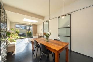 <h1><span> </span></h1><p><span>Een verrassend lichte woning met een warme uitstraling, een prachtige leefkeuken, drie slaapkamers én een gezellige tuin? Die vind je hier, in een aangename, residentiële buurt in Deurne-Zuid. Met z’n mooie mix van hout, staal en betonlook, slimme opbergruimtes en een fijne verbinding met de tuin heeft deze instapklare woning van ca. 121 m² heel wat troeven in huis!</span></p><p><span> </span></p><h3><span>Koken, tafelen en relaxen in het licht</span></h3><p><span>Je komt binnen via de inkomhal, waar je handig je jassen en schoenen kwijt kunt. Van hieruit stap je meteen de grote open keuken binnen, die met z’n warme houten kastenwand en stoere inox afwerking een echte eyecatcher is. Het grote kookeiland met chromen werkblad, geïntegreerde spoelbak en gezellige zitplek nodigt uit om samen te aperitieven terwijl er gekookt wordt. Je hebt hier een vijfpits gasvuur, dampkap, oven, ingebouwde vaatwasser en vooral héél veel kastruimte. Een grote ramenpartij zorgt voor natuurlijk licht en verluchting.</span></p><p><span>Aansluitend kom je in de gezellige leefruimte, waar de donkere vloer mooi contrasteert met de lichte muren en warme houten accenten. Er is volop plaats voor een grote eettafel en een comfortabele zithoek. De zwarte industriële schuifdeuren met glas geven het geheel extra karakter en schermen de trap, de gang, het gastentoilet met handenwasser en een handige berging stijlvol af.</span></p><p><span>Achteraan trekt de grote lichtkoepel extra daglicht naar binnen, terwijl het kamerbrede schuifraam de tuin helemaal bij de leefruimte betrekt. Zodra het zonnetje schijnt, zet je de deur open en loopt binnen moeiteloos over in buiten. In de groene tuin geniet je van een stukje gazon, siergrassen, planten en een gezellig terras waar je heerlijk kunt tafelen. </span></p><p><span> </span></p><h3><span>Warme parketvloeren en een badkamer met alles erop en eraan</span></h3><p><span>Via de houten trap met sfeervolle ingebouwde verlichting ga je naar de eerste verdieping. Op de overloop ligt een mooie parketvloer en vind je een hele reeks ingemaakte kasten. Ideaal om kleding, beddengoed en allerlei spullen netjes uit het zicht op te bergen.</span></p><p><span>De ruime slaapkamer van ca. 13 m² heeft dezelfde warme parketvloer, een groot raam en een strak, verticaal verwarmingselement. Een fijne plek om helemaal tot rust te komen.</span></p><p><span>De badkamer is een echte wellnessplek, met een moderne grijze tegelvloer, een ruime inloopdouche in betonlook met regendouche én een ligbad. Het brede badkamermeubel heeft twee witte opzetlavabo’s, ingebouwd kraanwerk en heel wat opbergruimte. De grote spiegel met houten omlijsting zorgt voor een warm accent. Je hebt hier ook een hangtoilet, een zwarte industriële radiator met handdoekdrager en twee ramen voor natuurlijk licht en verluchting.</span></p><p><span> </span></p><h3><span>Twee gezellige kamers onder het dak</span></h3><p><span>Via de stoere zwarte stalen trap met houten treden bereik je de tweede verdieping. Hier vind je nog twee gezellige slaapkamers, allebei met een parketlaminaatvloer en een groot Veluxraam dat voor veel daglicht zorgt. De schuine dakvlakken geven de kamers extra charme en dankzij de ingemaakte kasten onder het dak gaat er geen plaats verloren. Perfect als kinderkamers, logeerkamer of thuisbureau. Ook op de overloop vind je nog extra kastruimte.</span></p><p><span> </span></p><p><span>Rustig wonen met alles dichtbij</span></p><p><span>De Waterbaan ligt in een aangename, residentiële buurt in Deurne-Zuid, waar je rustig woont en toch alles binnen handbereik hebt. Voor je dagelijkse boodschappen kun je terecht bij de buurtwinkels en supermarkten in de omgeving van de Herentalsebaan. Ook scholen, andere voorzieningen en de herkenbare Sint-Rochuskerk liggen vlakbij.</span></p><p><span>De tramhalte Deurne Waterbaan bevindt zich op wandelafstand, net als verschillende bushaltes. Zo verplaats je je vlot richting het centrum van Antwerpen en de omliggende wijken. Een fijne locatie dus voor wie graag rustig woont, maar de stad niet wil missen!</span></p><p><span> </span></p><p><span> </span></p>