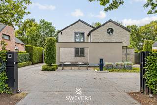 Voor meer info en foto’s, surf naar www.swevers.be – Deze open bebouwing in Zonhoven, gebouwd in 2005 en tussen 2021 en 2025 grondig geoptimaliseerd, biedt instapklaar en energiezuinig wooncomfort. De woning beschikt over een zuidgericht perceel van 12 are 33 ca met een tuin van 713,98 m², een terras van 40 m² en een verwarmd zwembad op 21 zonnepanelen.<br />Binnen geniet u van een inkomhal met gastentoilet, een lichtrijke leefruimte van 34,43 m² met gashaard en directe toegang tot het terras, en een ruime keuken van 24,99 m² uitgerust met drie ovens, een stockageruimte en aparte zij-ingang. Verder is de woning volledig onderkelderd met natuurlijke lichtinval via lichtkoepels en ingericht met kelderberging, wasplaats, bureau en een atelier/mancave van 41 m².<br />Op de verdieping vindt u vier volwaardige slaapkamers (28,35 m², 20,59 m², 16,20 m² en 11,12 m²) met ingemaakte kasten, een badkamer met ligbad, dubbele wastafel en infraroodsauna, een aparte douchekamer en apart toilet.<br />Extra troeven zijn de dubbele carport, fietsenberging, vernieuwde zwembadinstallatie, airco’s, laadpaal, vernieuwde verwarmingsketel en versterkte elektriciteit, evenals een volledig uitgerust poolhouse met eigen ingang, living, keuken, badkamer en slaapkamer – ideaal als gastenverblijf of praktijkruimte.<br />Gelegen op 450 m van scholen en openbaar vervoer, 400 m van restaurants, 2,4 km van winkels en 5,4 km van de snelweg, nabij natuurgebied De Platwijers. Voor meer informatie, bel 011 255 155. Bron bewoonbare oppervlakte: EPC – verslag.
