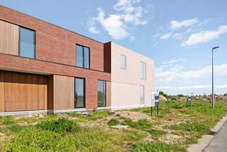 Binnen de ring van Roeselare, op het grondgebied van Hooglede, bevindt zich deze moderne halfopen woning met plat dak (lot 88). De woning beschikt over een lichtrijke leefruimte, een kwalitatief ingerichte open keuken en een ruime garage ernaast die doorloopt naar de aansluitende wasplaats die meteen ook weer toegang biedt tot de tuin. Er zijn 2 aparte toiletten. Eén op elke verdieping. Boven bevinden zich 4 slaapkamers, een badkamer met douche én bad en een aparte berging. De woning werd reeds opgebouwd en wordt door Dumobil verder afgewerkt volgens de wensen van de koper en volledig instapklaar opgeleverd. Voorzien van alle nodige vloerbekleding, met aangelegde tuin voorzien van een afsluiting, terras en gazon en een aangelegde voortuin met oprit en pad naar de voordeur.<br /><br />Door de combinatie van het warmtenet en zonnepanelen verwarm je duurzaam met vloerverwarming en de nieuwste technieken. Met een E-peil onder de 20 geniet je van heel wat voordelen en als bewoner van dit futureproof woonproject beschik je daarbij over alle faciliteiten van het e-mobipunt. Er is een vlotte verbinding met de ring rond Roeselare en het centrum van Roeselare.<br /><br />Deze all-inprijs excl. kosten omvat een volledig afgewerkte, instapklare woning met álle voorzieningen en omgevingswerken inbegrepen. De totale kostprijs inclusief wettelijke kosten waaronder registratierechten, btw, notariskosten en aansluitingskosten kan je eenvoudig bekijken op onze <u><strong>website</strong></u>: <u><strong>www.dumobil.be/nl/woonprojecten/projecten/hooglede-nieuwbouwwoningen</strong></u> En/of contacteer onze bouwadviseur Sam Borrey voor meer info: 0483/21.01.33 | sam@dumobil.be