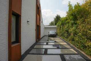 Zeer recent gerenoveerde woning in uitstekende staat met directe toegang tot uitvalswegen naar Brussel, Gent en Antwerpen.<br /><br />Op een totale oppervlakte van meer dan 900m² ligt een prachtig aangelegde tuin met vijverpartijen in cortenstaal, een vernieuwde oprit met ruime parking en een woning met verbonden woonruimte.(50m²)(uitbreiding hoofdgebouw, dus hetzelfde huisnummer). Gelijkvloers 123m²,1ste verdieping 77m² en 2de verdieping 63m². Wat een totaal geeft aan meer dan 300m² bewoonbare oppervlakte. <br /><br />De woning is dit jaar volledig opnieuw gekaleid en afgewerkt met cortenstaal. De voordeur en schuiframen voor-en achteraan (incl. inbraak werende extra folie) werden zeer recent vervangen door hoog rendement glas.<br /><br />De EPC waarde B wordt oa bekomen met vernieuwde extra isolatie, in 2022 (nog in garantie) geplaatste 24 hoog rendement zonnepanelen, incl. omvormer en een 10KW batterij, een hoog rendement condensatieketel op gas en 2 groendaken.<br /><br />De volledige woning heeft hoge afwerkingsgraad op maat, beschikt over inbraak- en brandalarm en is vooraan voorzien van camerabewaking. Er is ook een droge kruipkelder aanwezig.<br /><br />De woning werd gebouwd in 1979 maar werd verbouwd in 2004,2006, 2012, 2022, 2023, 2024 en 2026 en wordt verkocht wegens verhuis naar het buitenland (omwille van gezondheid). Alle verbouwingen zijn vergund. De woning heeft een septische tank en is gekoppeld aan de riolering.<br /><br />