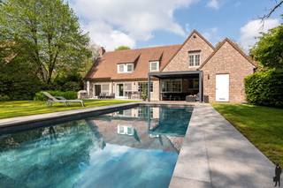 <strong>Exclusieve en tijdloze villa (ca. 2.032 m²) met zwembad in doodlopende straat.</strong><br /><br /><strong>In een doodlopende, residentiële straat bevindt zich deze stijlvolle villa op een riant perceel van ca. 2.032 m². De woning straalt klasse en comfort uit, met een doordachte indeling, hoogwaardige afwerking en een prachtig aangelegde tuin met zwembad. Een ideale combinatie van rust, privacy en hedendaags wooncomfort.</strong><br /><br /><strong>De gelijkvloerse verdieping: </strong><br />- Een <strong>inkomhal</strong> met vestiaire, gastentoilet en handenwasser, <br />- Een lichtrijke <strong>woonkamer </strong>op parket met ingemaakte kasten en een <strong>open haard</strong>, <strong>grote raampartijen</strong> en een dubbel schuifraam met <strong>directe toegang tot de tuin</strong><br />- Een aparte <strong>televisie</strong>-<strong> of familiekamer</strong>, bereikbaar via een stijlvolle stalen deur<br />- Een volledig ingerichte <strong>keuken </strong>met ingemaakte kasten, <strong>eiland</strong> en <strong>ontbijthoek</strong>: en dubbele lavabo, Miele inbouwtoestellen (oven, stoomoven, warmhoudlade, koelkast, vaatwasser en inductiekookplaat), afgewerkt met een Novy dampkap en een mooi zicht op de tuin<br />- Een aansluitende <strong>wasplaats </strong>met maatkasten, cv-installatie (Vaillant), <strong>zij-ingang</strong> en extra bergruimte<br /><br /><strong>De eerste verdieping:</strong><br />- Een <strong>nachthal</strong><br />- Een <strong>eerste slaapkamer</strong> op parket<br />- Een <strong>eerste badkamer</strong> in marmer met lavabo, douche, toilet, handdoekradiator, sauna en ingemaakte kasten<br />- Een <strong>tweede slaapkamer</strong> op parket met ingemaakte kasten<br />- Een<strong> tweede badkamer</strong> met ligbad, douche, dubbele lavabo, toilet en handdoekradiator<br />- Een <strong>derde slaapkamer</strong> op parket met ingemaakte kasten<br />- Een<strong> ruime hoofdslaapkamer</strong> met <strong>dressing </strong>en maatkasten, aansluitend een <strong>derde badkamer</strong> in marmer met ligbad, douche, dubbele lavabo en toilet<br /><br /><strong>De zolder:</strong><br />- Een ruime <strong>bergzolder</strong>, bereikbaar via een vlizotrap<br /><br /><strong>De tuin:</strong><br />- Een <strong>prachtig </strong>aangelegde en volledig <strong>omheinde zuidoost tuin </strong>met optimale <strong>privacy</strong><br />- Een ruim <strong>terras</strong> en een <strong>overdekt terras</strong> met <strong>heaters</strong>, afsluitbaar voor extra comfort<br />- Een <strong>vernieuwd zwembad (4x10 meter) </strong>met solar rolluik en cv-ketel op gas (2017)<br />- Een praktische <strong>berging</strong> met <strong>zwembadtechnieken </strong>en <strong>toilet</strong><br /><br /><strong>Algemeen:</strong><br />- Verwarming op <strong>gas </strong>(Vaillant) via <strong>radiatoren en vloerverwarming</strong><br />- <strong>Instapklare</strong> en<strong> uitstekend onderhouden</strong> woning<br />- <strong>Kwalitatieve materialen</strong> en <strong>maatwerk</strong> doorheen de woning<br />- <strong>Rustige</strong> ligging in een <strong>residentiële </strong>en gegeerde omgeving<br /><strong>- Centraal stofzuigersysteem</strong><br /><strong>- Costermans-villa<br /></strong>