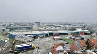 Aan de Zepperenweg 103-105 in Sint-Truiden bieden wij deze uitgebreide bedrijfssite aan met een totale oppervlakte van 1ha 28a 36ca. Het complex beschikt over circa 5.400 m² bebouwde oppervlakte en combineert bedrijfsgebouwen, burelen en een ruime woning. Momenteel heeft het complex een logistieke invulling.<br /><br /><strong>Ligging en indeling</strong><br /><br />De voorzijde van het perceel (circa 6.680 m²) is gelegen in woongebied, terwijl de achterzijde zich in industriegebied bevindt. Deze gemengde ligging biedt vele mogelijkheden. De bereikbaarheid is uitstekend dankzij de nabijheid van de expressweg en de makkelijke toegang.<br /><br /><strong>Bedrijfsgebouwen (ca. 5.000 m²)</strong><br />Het complex bestaat uit diverse loodsen en opslagruimtes die tussen 1977 en 1995 werden gebouwd. De infrastructuur omvat twee gesloten loodsen waarvan één verwarmde loods, twee open loodsen voor stockage, een garage met werkfosse en een apart magazijn. Voor logistieke activiteiten zijn er twee laadkaaien aanwezig, een carwash met olieafscheider en ruime manoeuvreerruimte.<br /><br />Naast de opslagruimtes beschikt de site over circa 250 m² bureelruimte en opslagruimte, evenals aparte personeelsvoorzieningen met refter en kleine keuken.<br /><br /><strong>Woning (ca. 200 m²)</strong><br />De woning beschikt over een bewoonbare oppervlakte van ongeveer 200 m² en heeft een ruime living, keuken, drie slaapkamers, een badkamer en een ruime kelder met garage van 180 m². De woning heeft EPC-label D en dient opgefrist of gerenoveerd te worden. Ideaal voor een eigenaar-zaakvoerder of om te verhuren.<br /><br /><strong>Technisch</strong><br />De site is technisch goed uitgerust. De elektrische installatie is volledig conform gekeurd en de mazoutverwarming zijn eveneens conform. Op het dak zijn 96 zonnepanelen geïnstalleerd met een totaal vermogen van 39.840 Wp, wat zorgt voor een aanzienlijke energieproductie.<br /><br /><strong>Samenvatting</strong><br />Totale oppervlakte: 1ha 28a 36ca, deels woongebied en deels indudstriegebied.<br />Bebouwde oppervlakte: ca. 5.400 m²<br />Bedrijfsruimte: ca. 5.000 m² loodsen + 250 m² bureel<br />Woning: ca. 200 m²<br />Zonnepanelen: 48 stuks (19.920 Wp)<br />Bouwjaren: 1977-1995<br /><br />Voor meer informatie of een bezichtiging, contacteer ons kantoor.